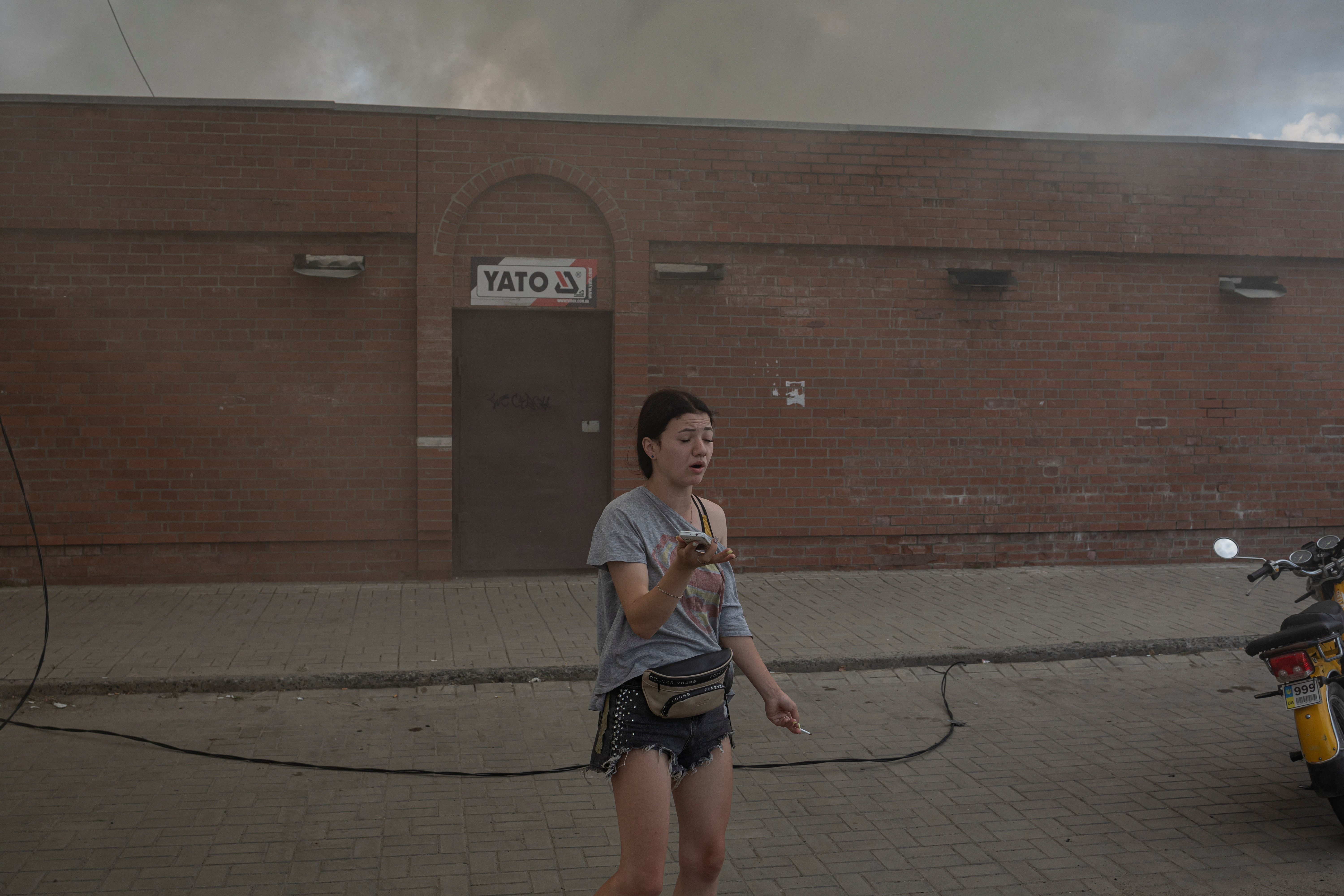 A woman stands in front of the market after shelling in Sloviansk