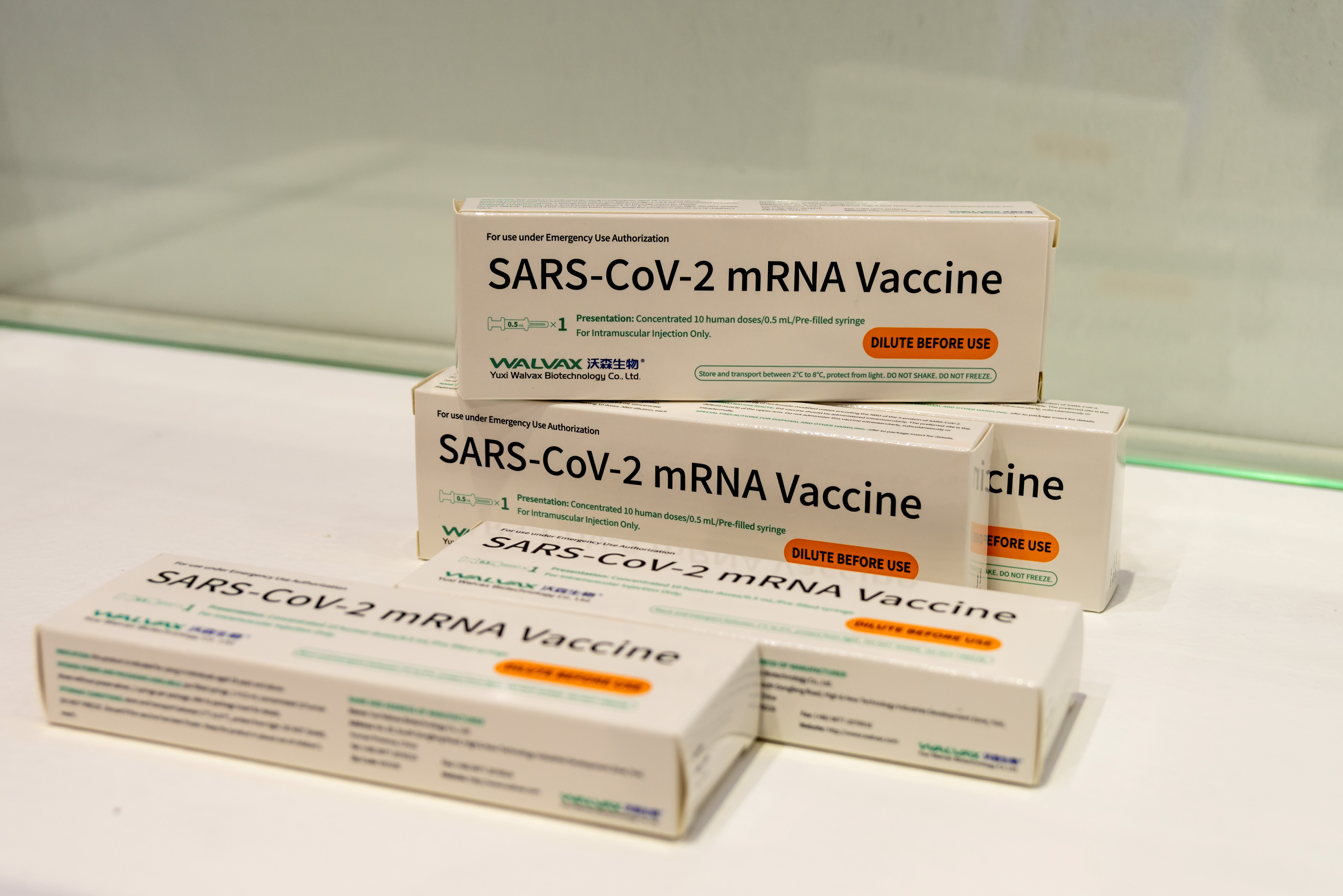 Boxes of Walvax Biotechnology's mRNA COVID-19 vaccine are displayed at a trade fair in Shanghai