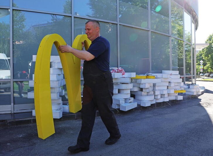 Workers dismantle a McDonald's sign from a restaurant in Saint Petersburg