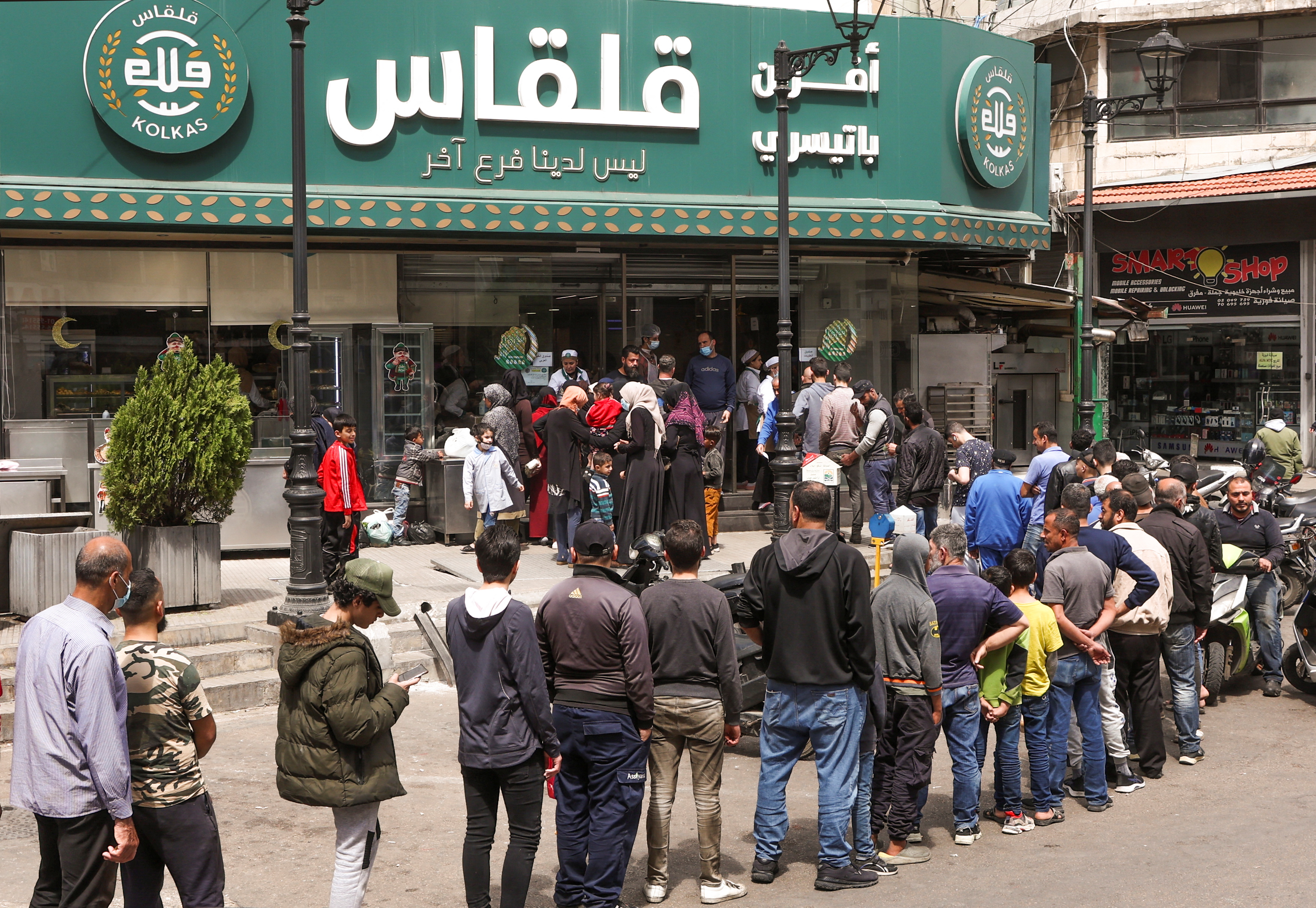 People queue to buy bread outside a bakery in Beirut