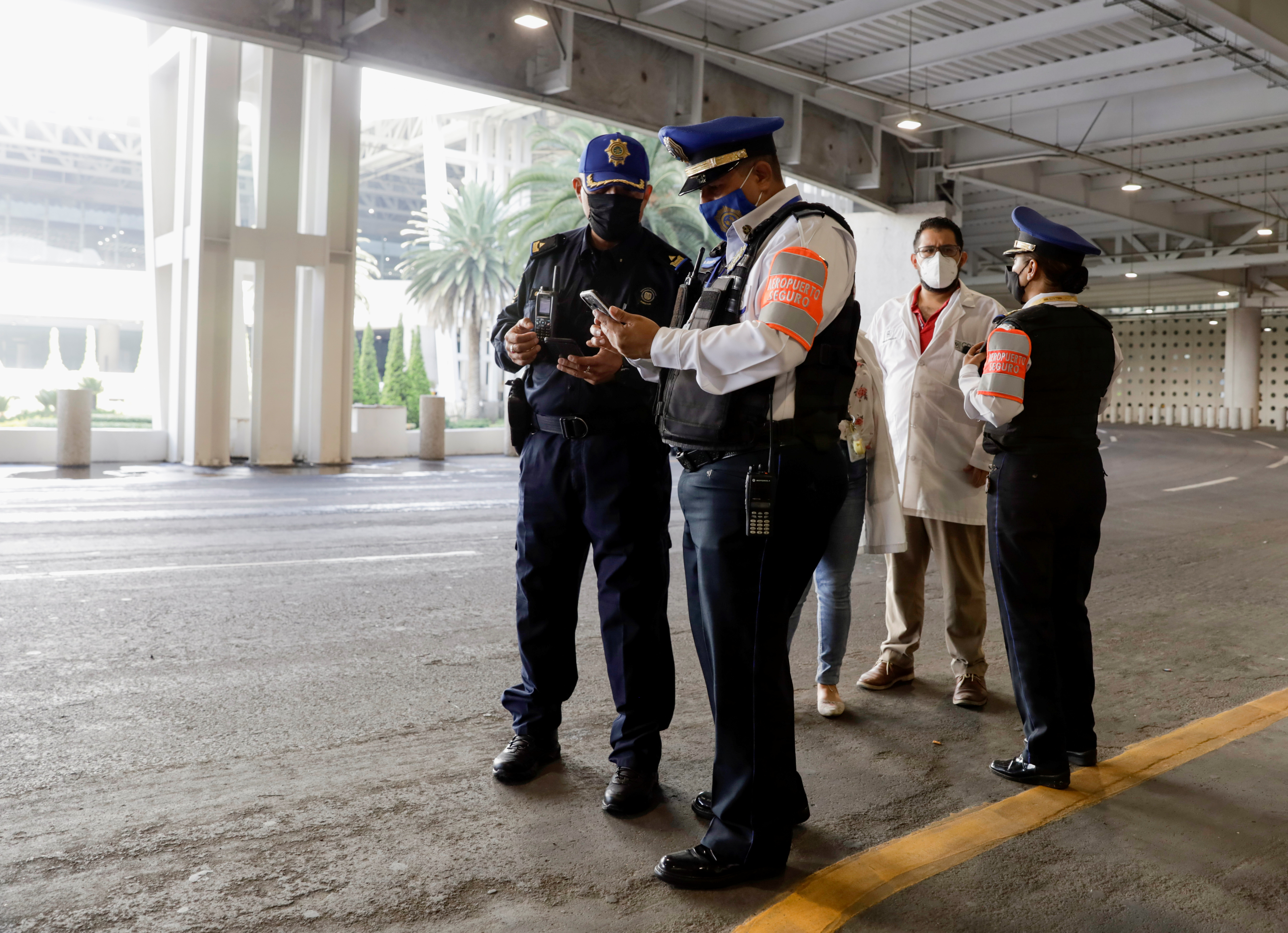 Agents of the city's prosecutors office and police officer collect information outside the airport, in Mexico City