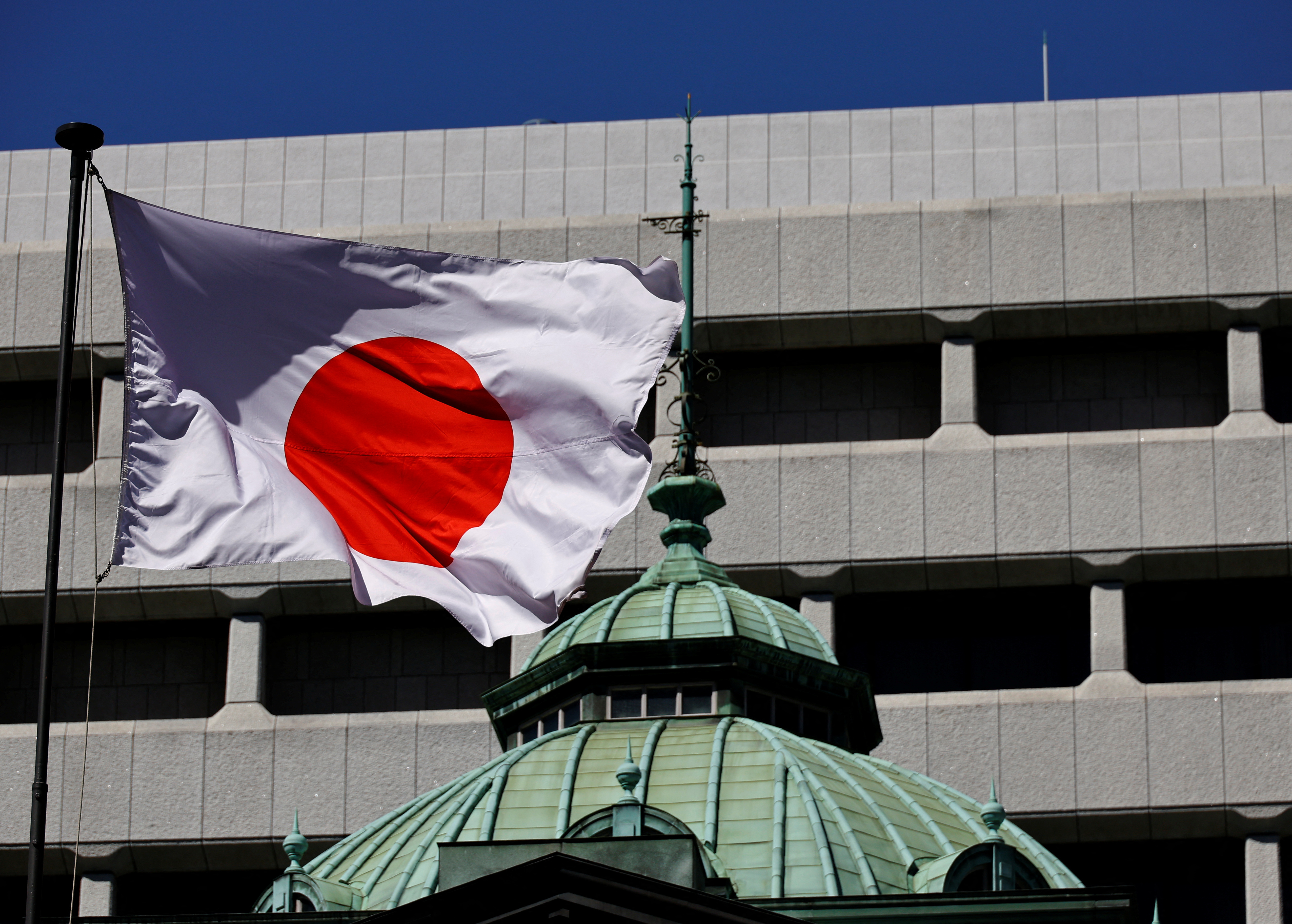 Japanese national flag waves at the Bank of Japan building in Tokyo