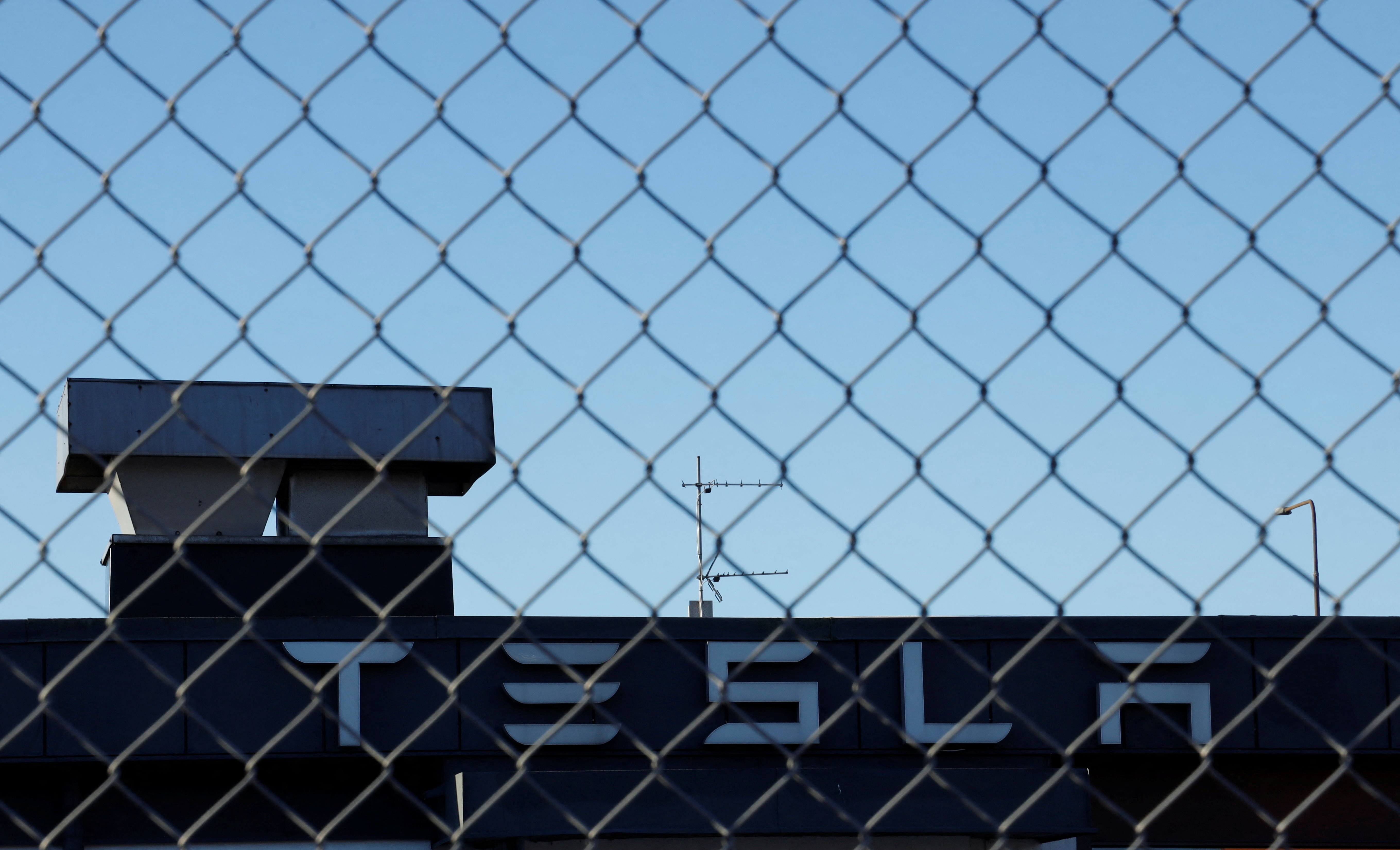 A Tesla sign is displayed over a Tesla showroom in Malmo