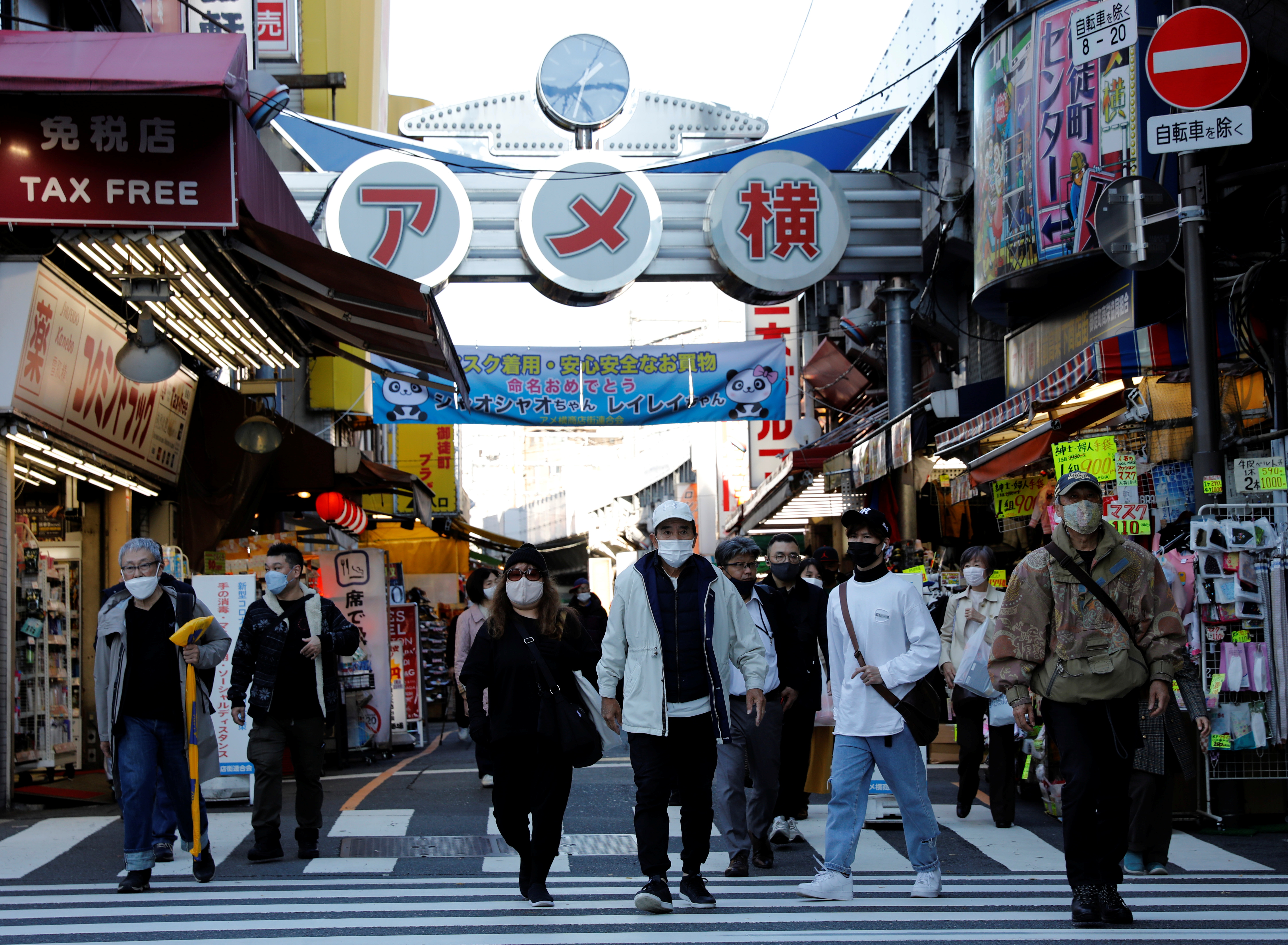 Pedestrians wearing protective masks, amid the coronavirus disease (COVID-19) outbreak, make their way at the Ameyoko shopping district in Tokyo
