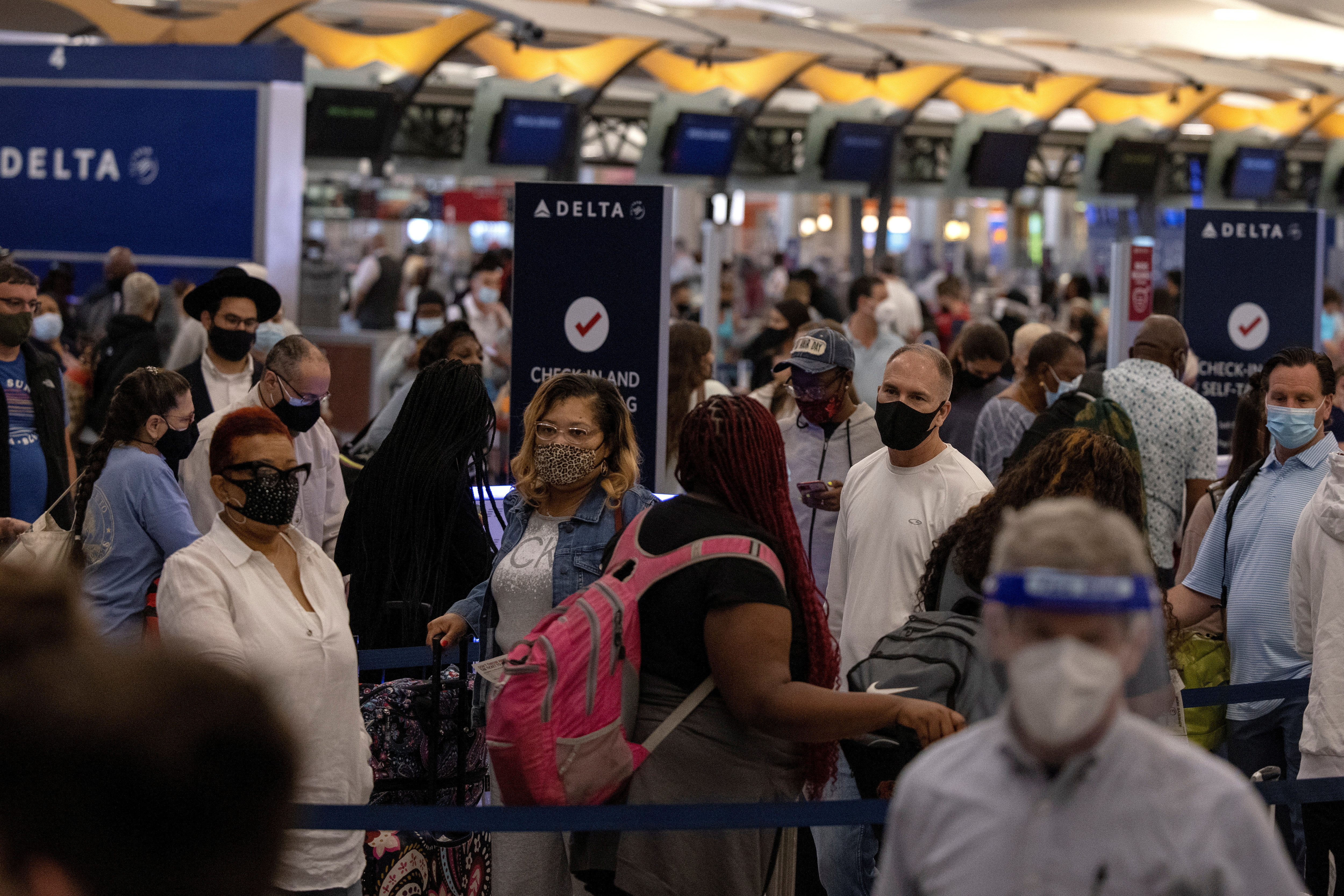 Passengers gather near Delta airline's counter as they check-in their luggage at Hartsfield-Jackson Atlanta International Airport, in Atlanta