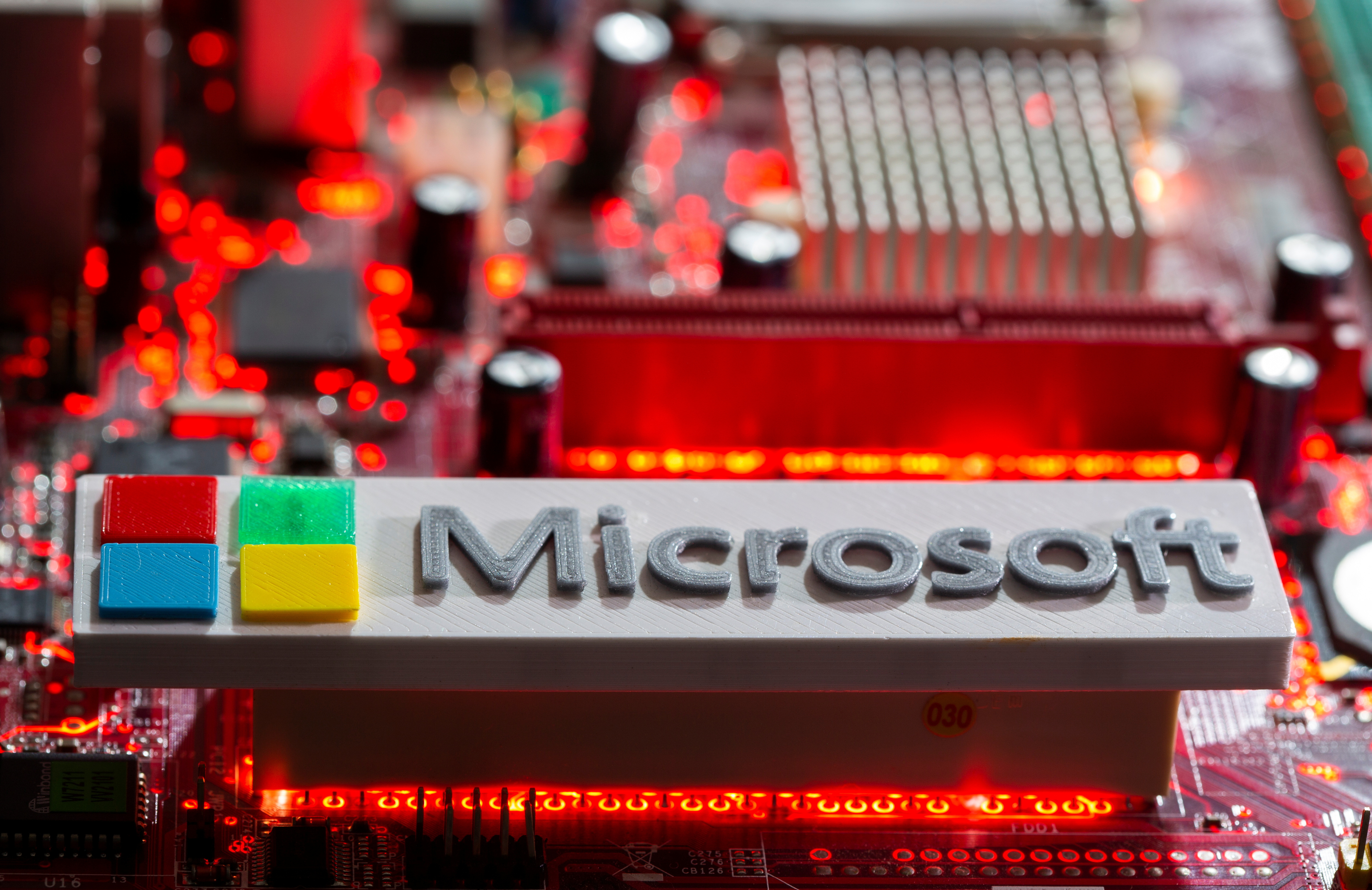 A 3D-printed Microsoft logo is seen on a computer motherboard in this picture illustration