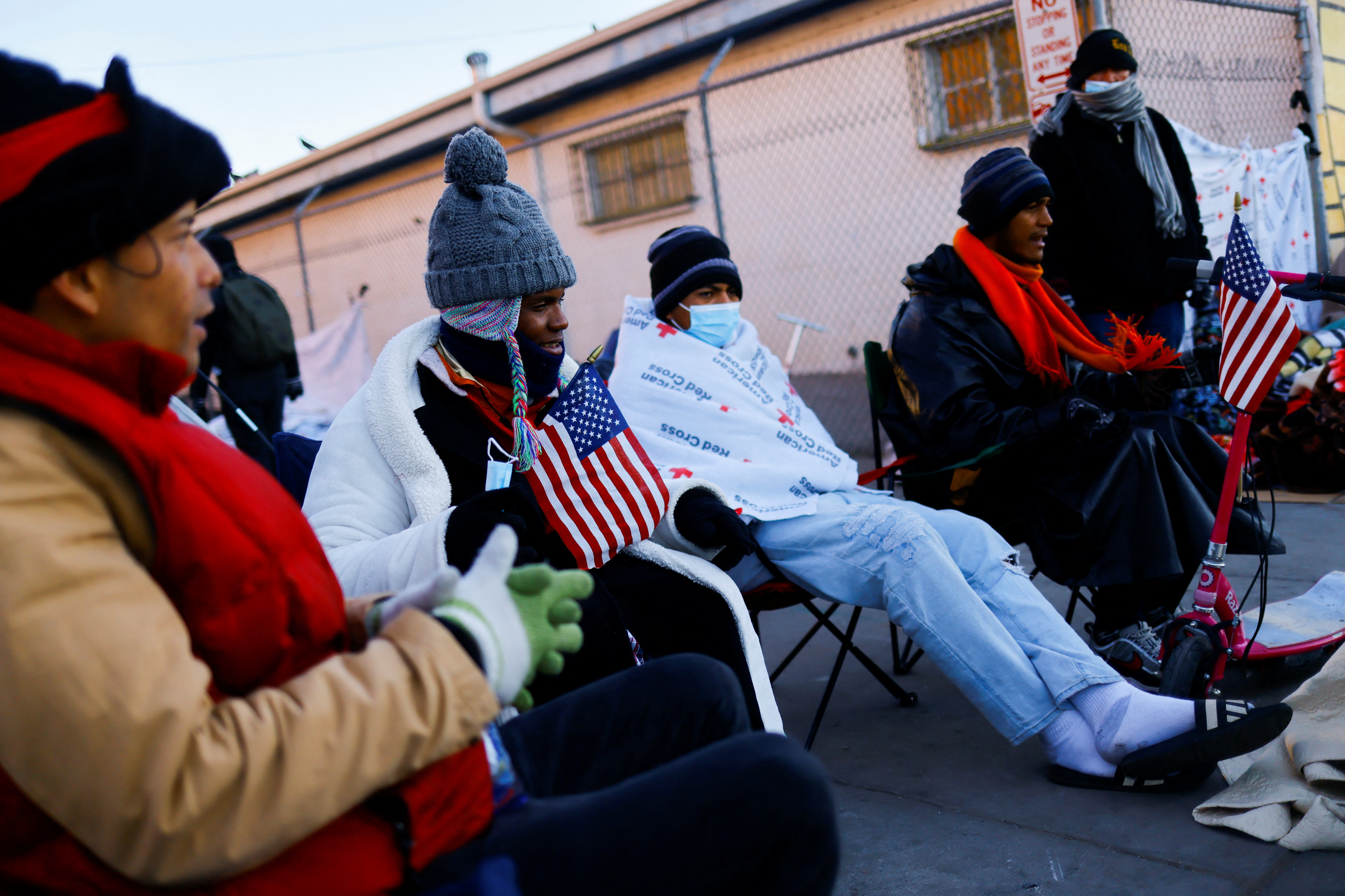 Migrants sit in foldable chairs on the day that U.S. President Biden and first lady Jill Biden visit El Paso