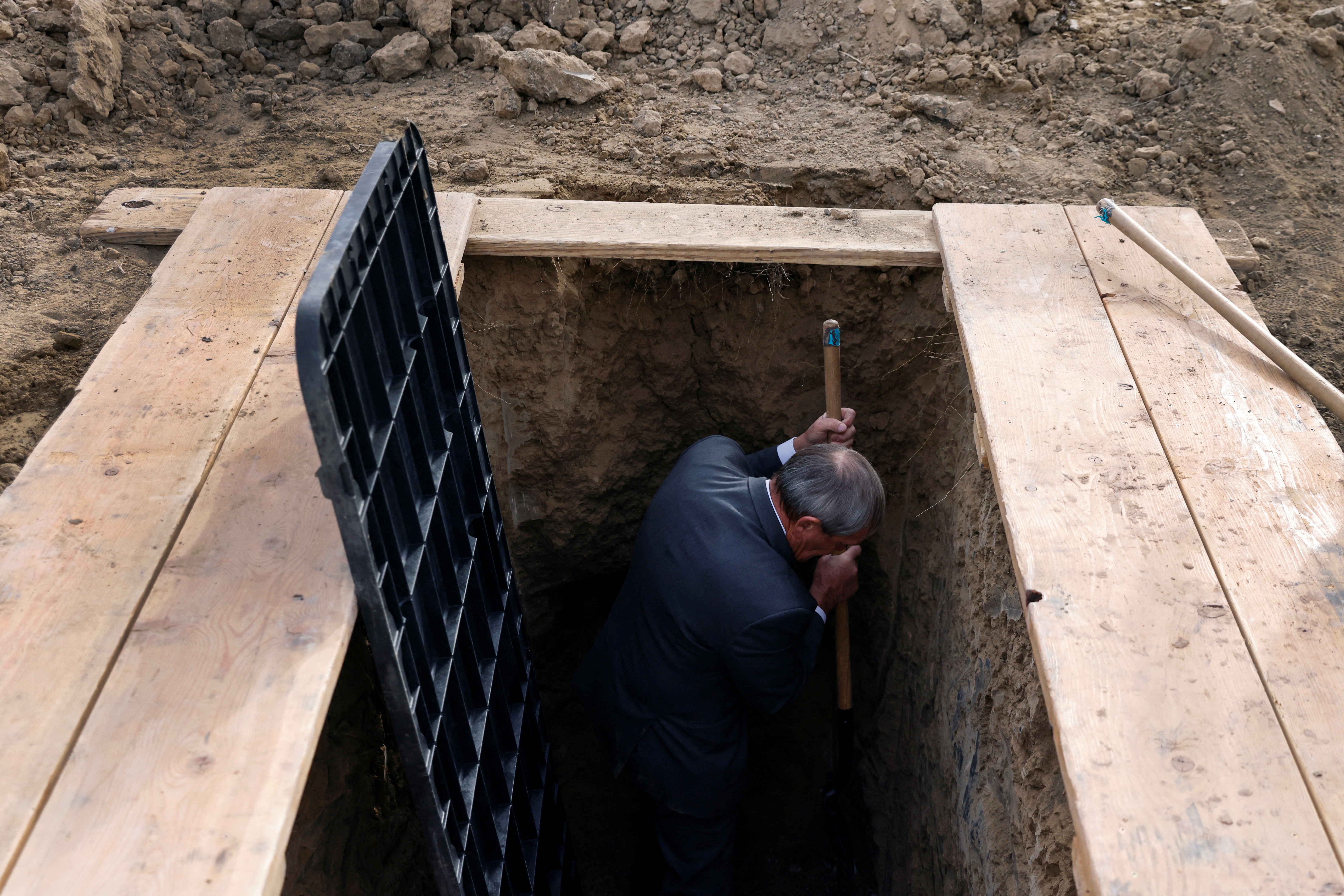 Lowell Jackson, a funeral worker, helps dig the gravesites of brothers Severiano Buck and Bace Wallace, who both died from complications of the coronavirus disease (COVID-19), before their burial at the family plot on the Sanostee chapter of the Navajo nation in Sanostee, New Mexico, U.S., December 16, 2021.  REUTERS/Shannon Stapleton