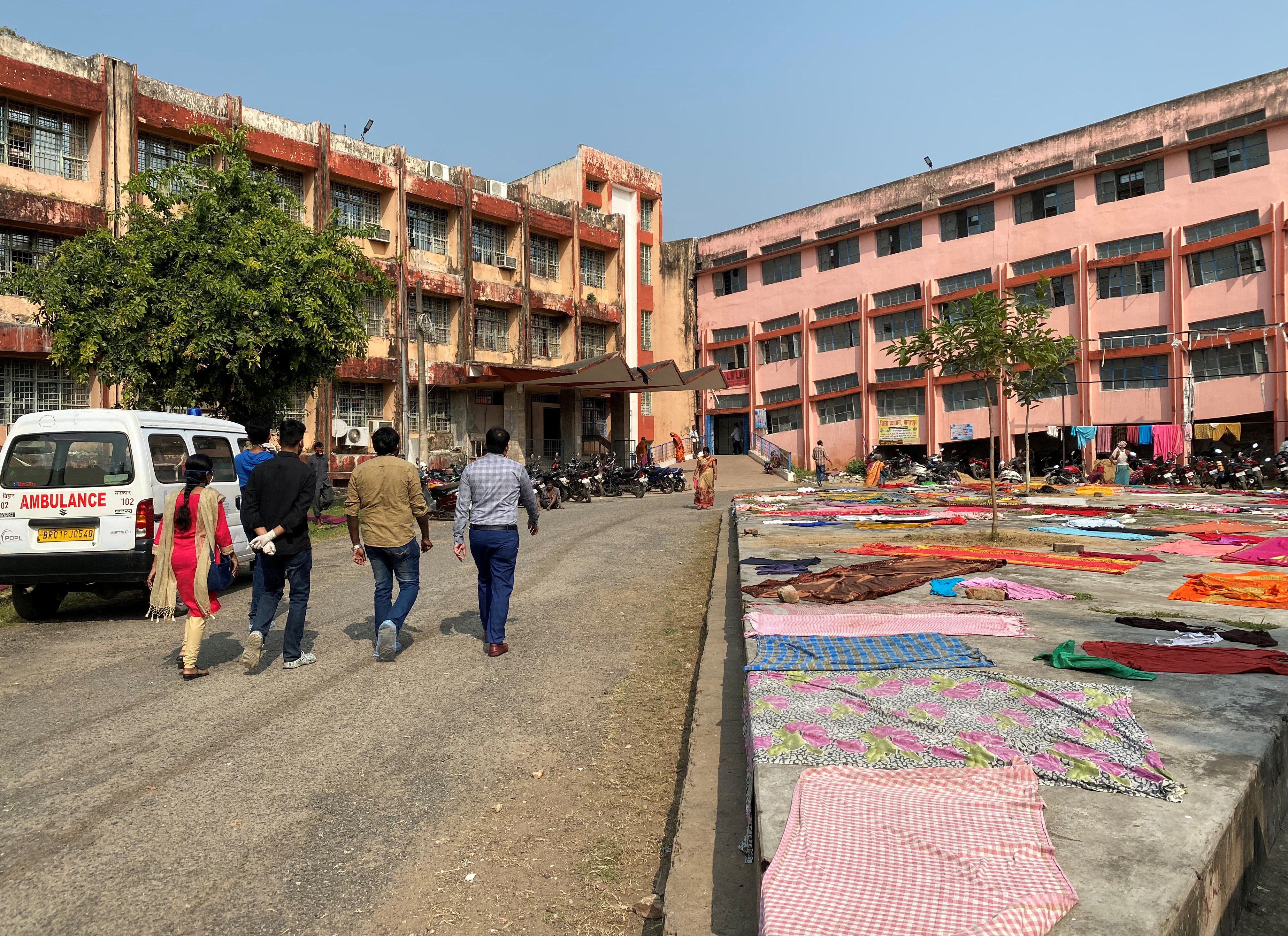 Doctors walk towards the main building of the Jawaharlal Nehru Medical College and Hospital in Bhagalpur district