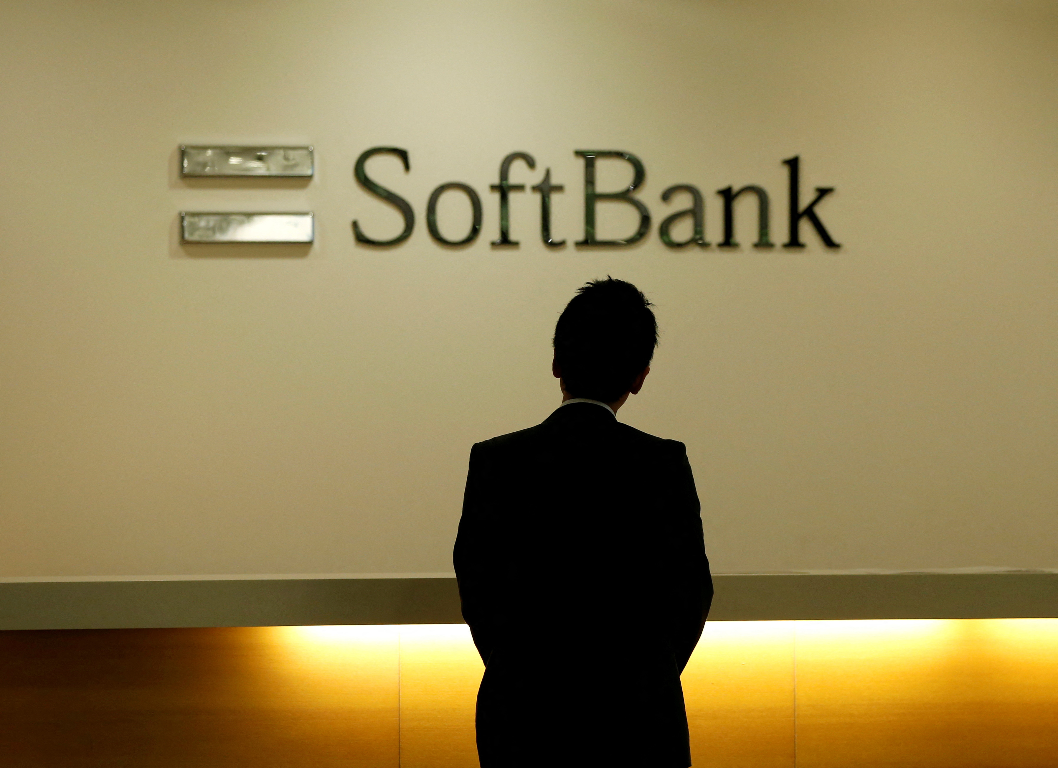 L'uomo guarda il logo di SoftBank Group Corp presso la sede centrale della società a Tokyo