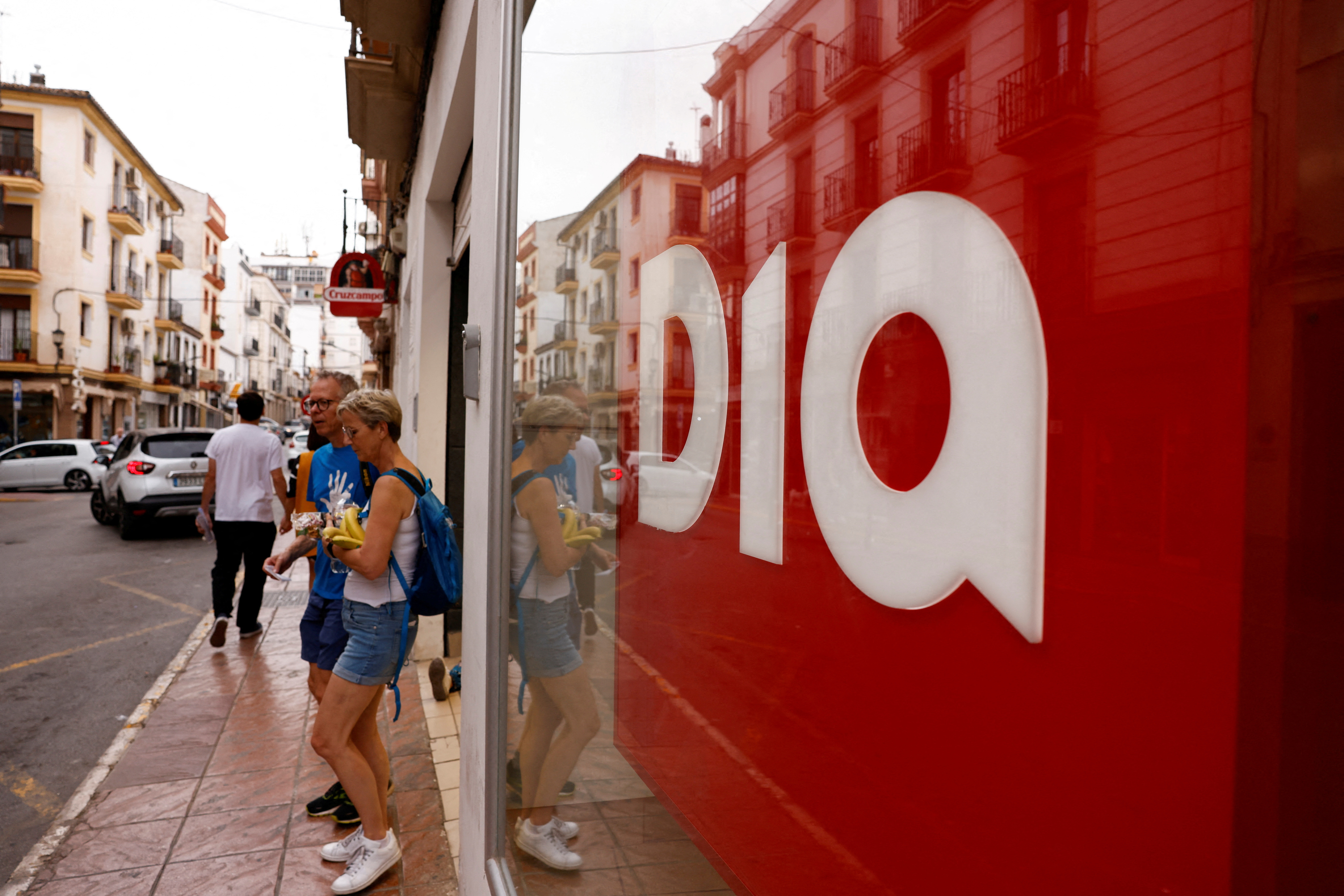 People leave a DIA supermarket in Ronda