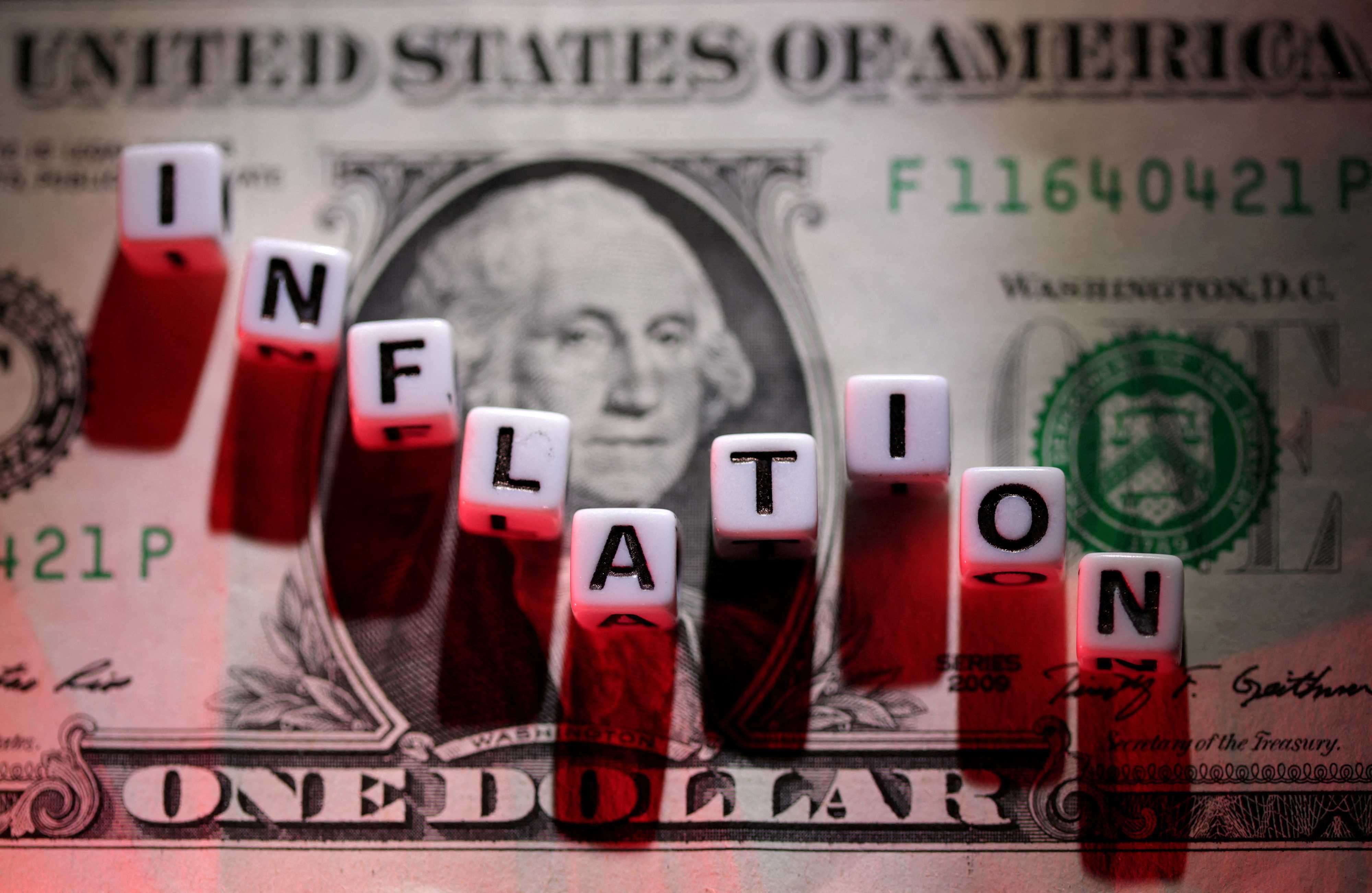 Illustration shows plastic letters arranged to read "Inflation" are placed on U.S. dollar banknote