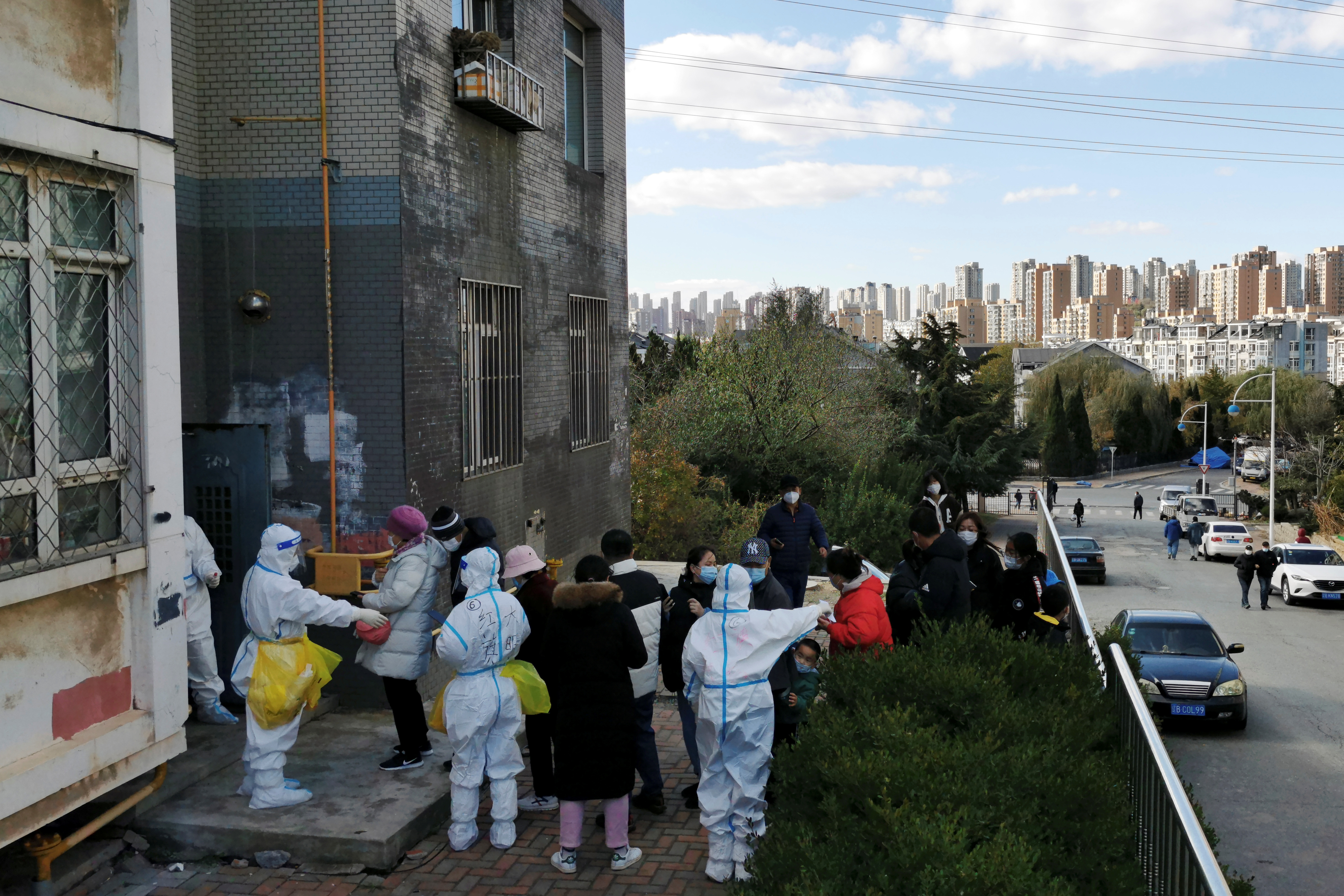 People line up for nucleic acid testing at a residential compound following local cases of the coronavirus disease (COVID-19) in Dalian, Liaoning province, China November 10, 2021. China Daily via REUTERS