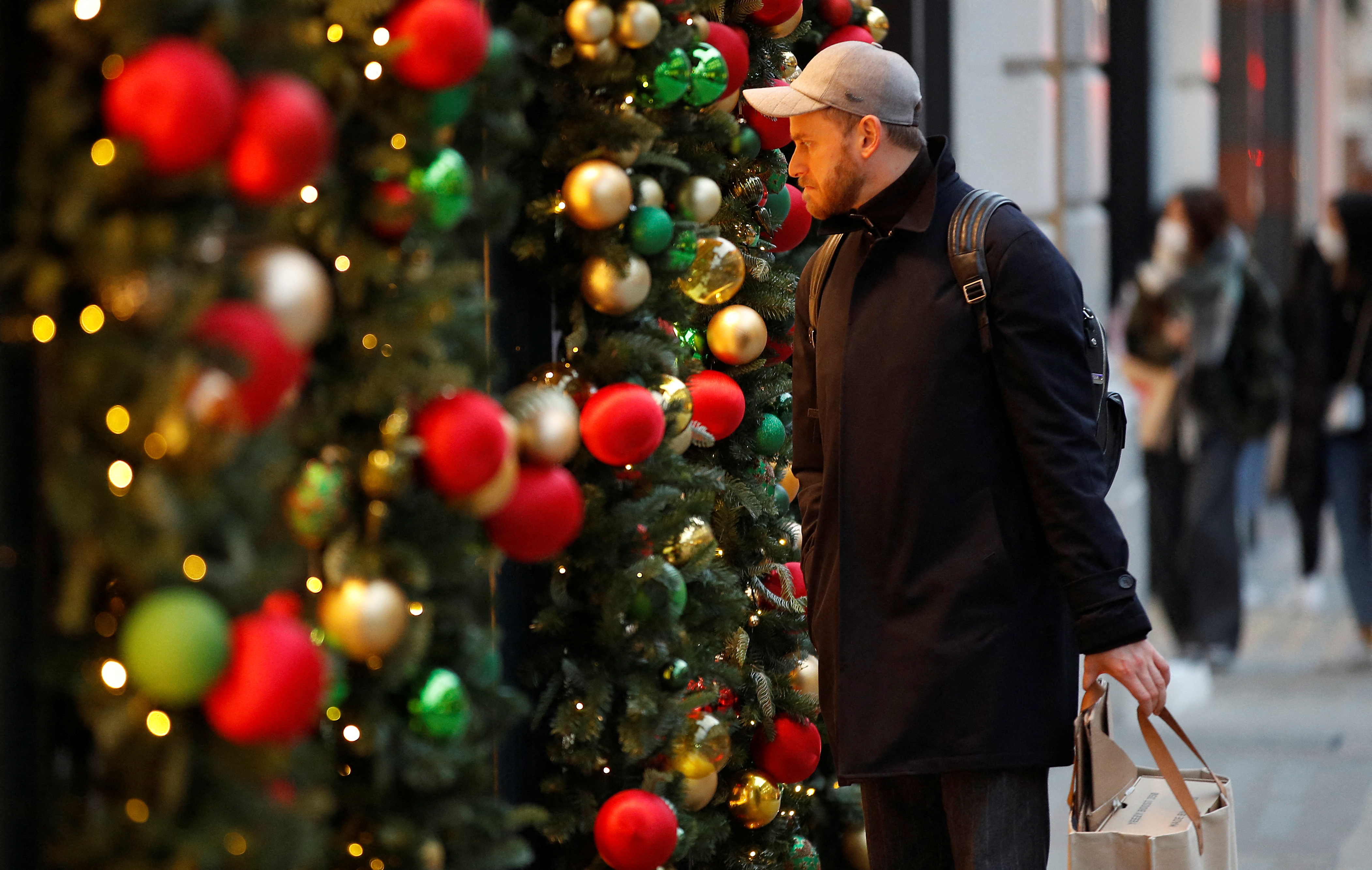 A man looks into a store decorated for Christmas on New Bond Street amid the coronavirus disease (COVID-19) outbreak in London, Britain, December 21, 2021.  REUTERS/Peter Nicholls