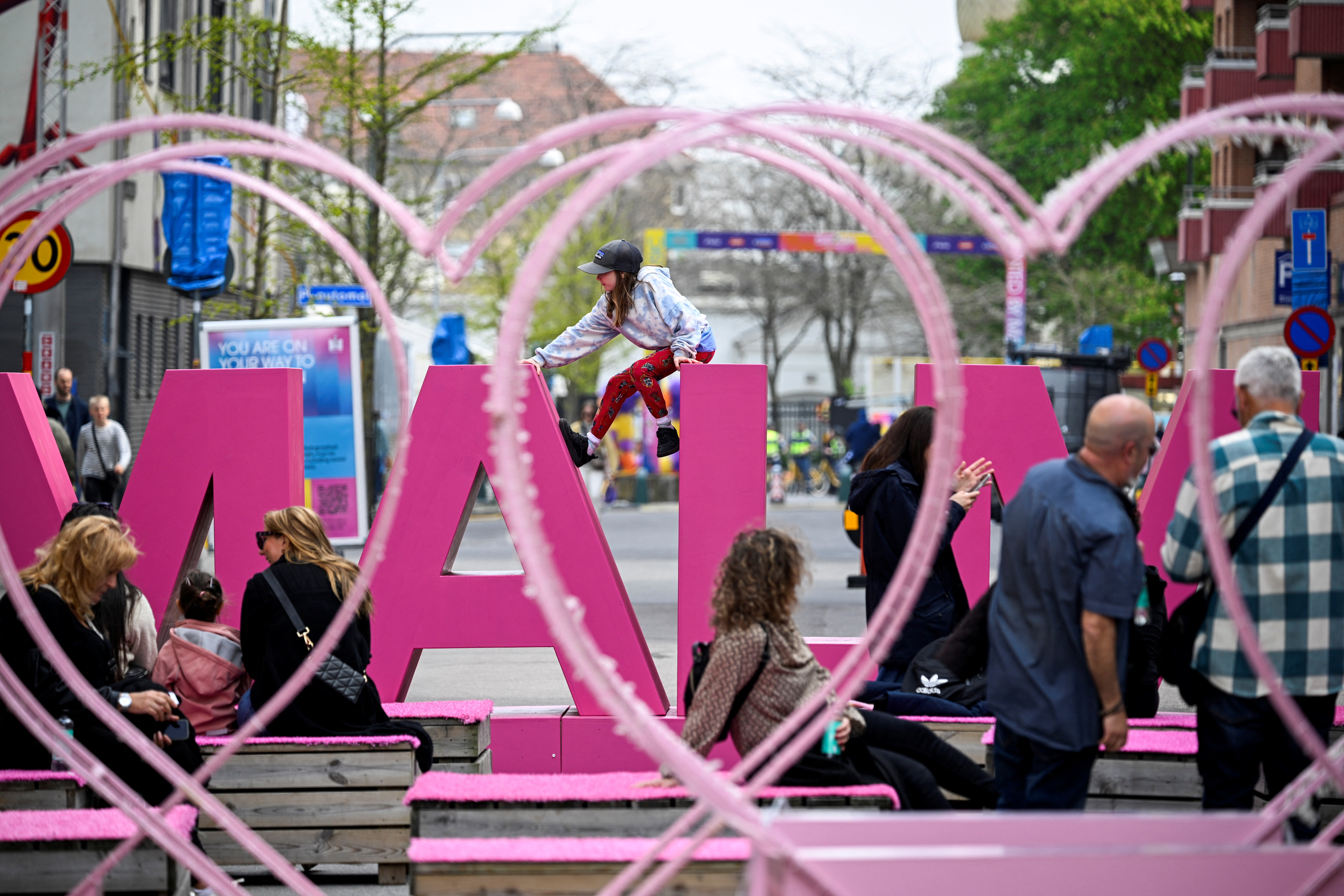 A child sits on a sign, ahead of the Eurovision Song Contest, in Malmo