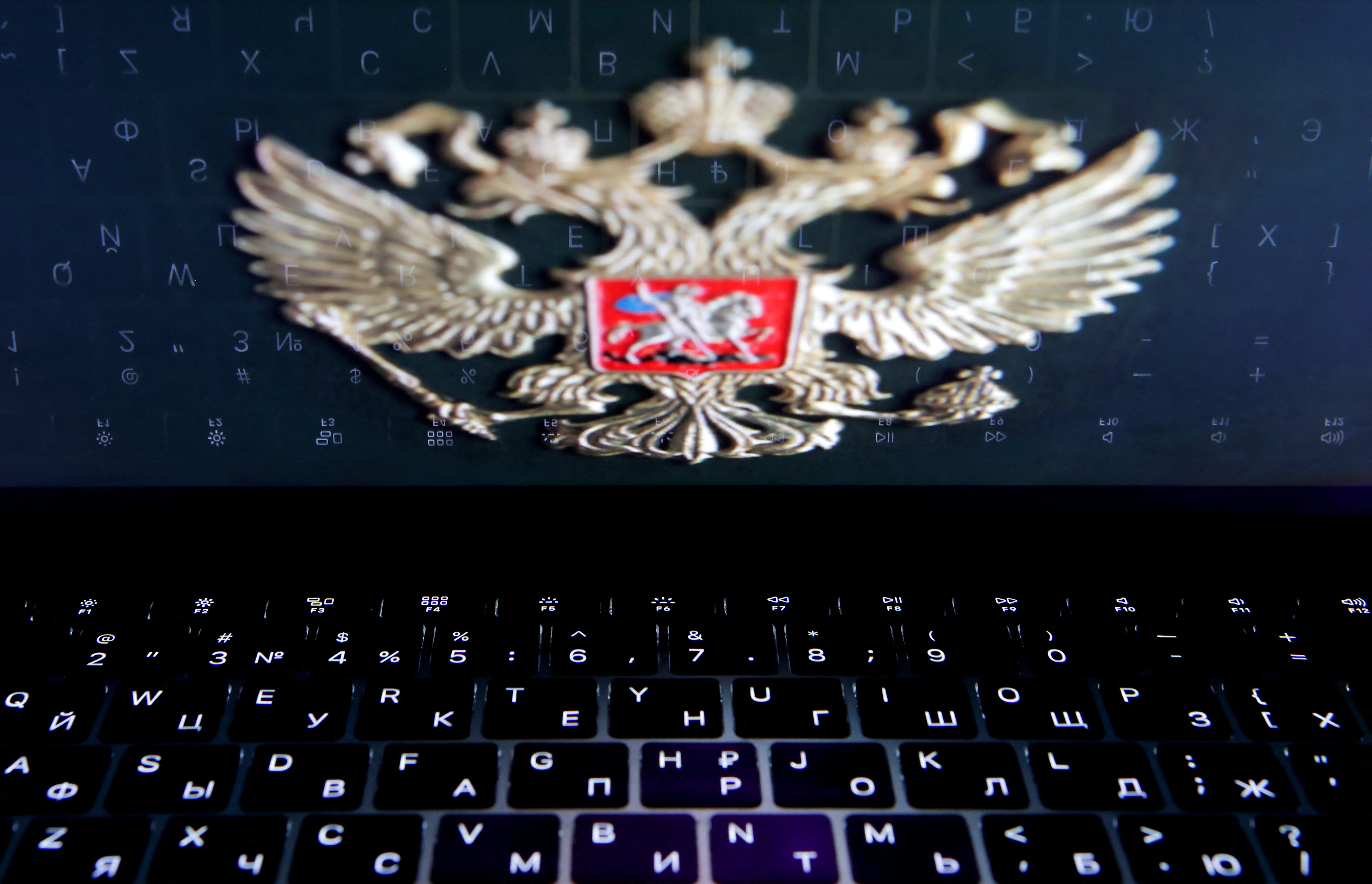 The coat of arms of Russia is reflected in a laptop screen in this picture illustration