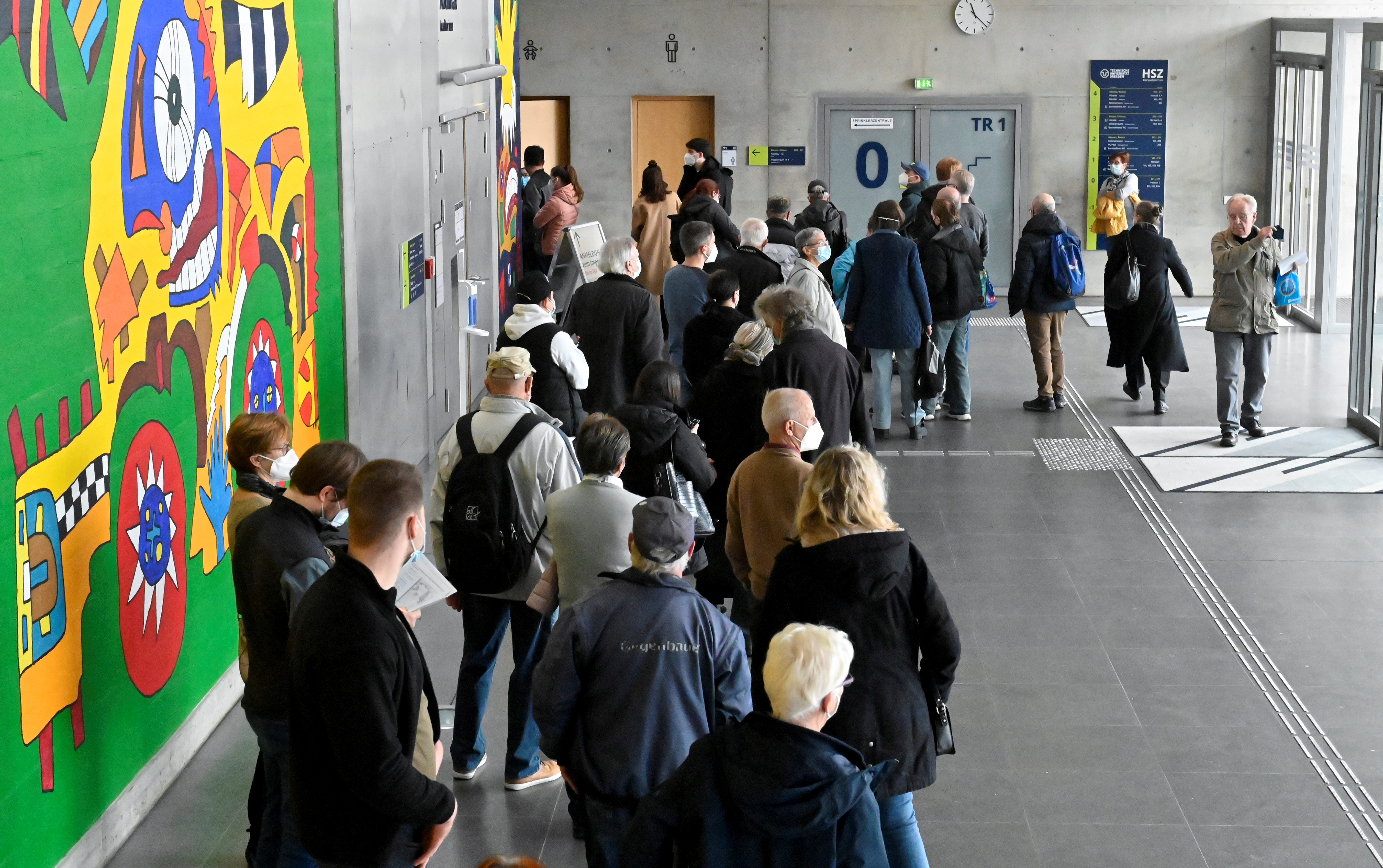 אנשים עומדים בתור לחיסון במרכז חיסונים זמני בתוך בניין הקמפוס של אוניברסיטת Technische Universitaet בדרזדן, גרמניה, 8 בנובמבר 2021. REUTERS/Matthias Rietschel