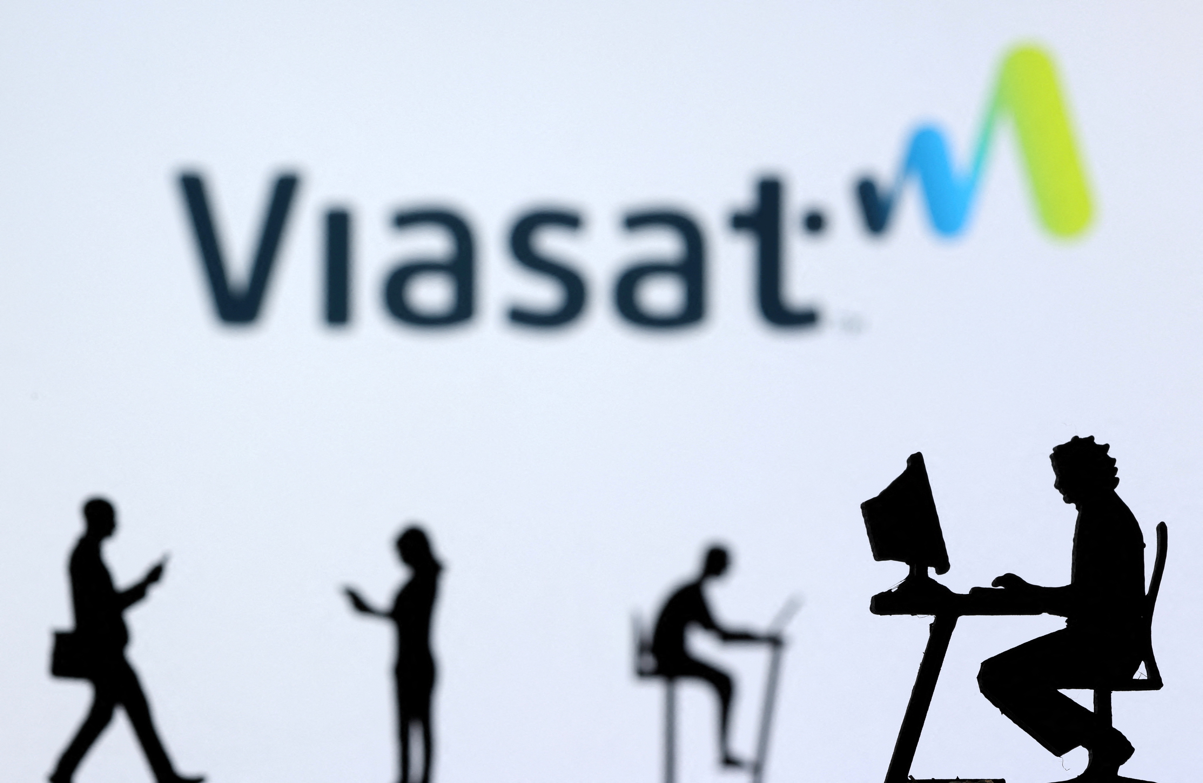 Illustration shows small toy figures with laptops and smartphones in front of displayed Viasat Internet logo