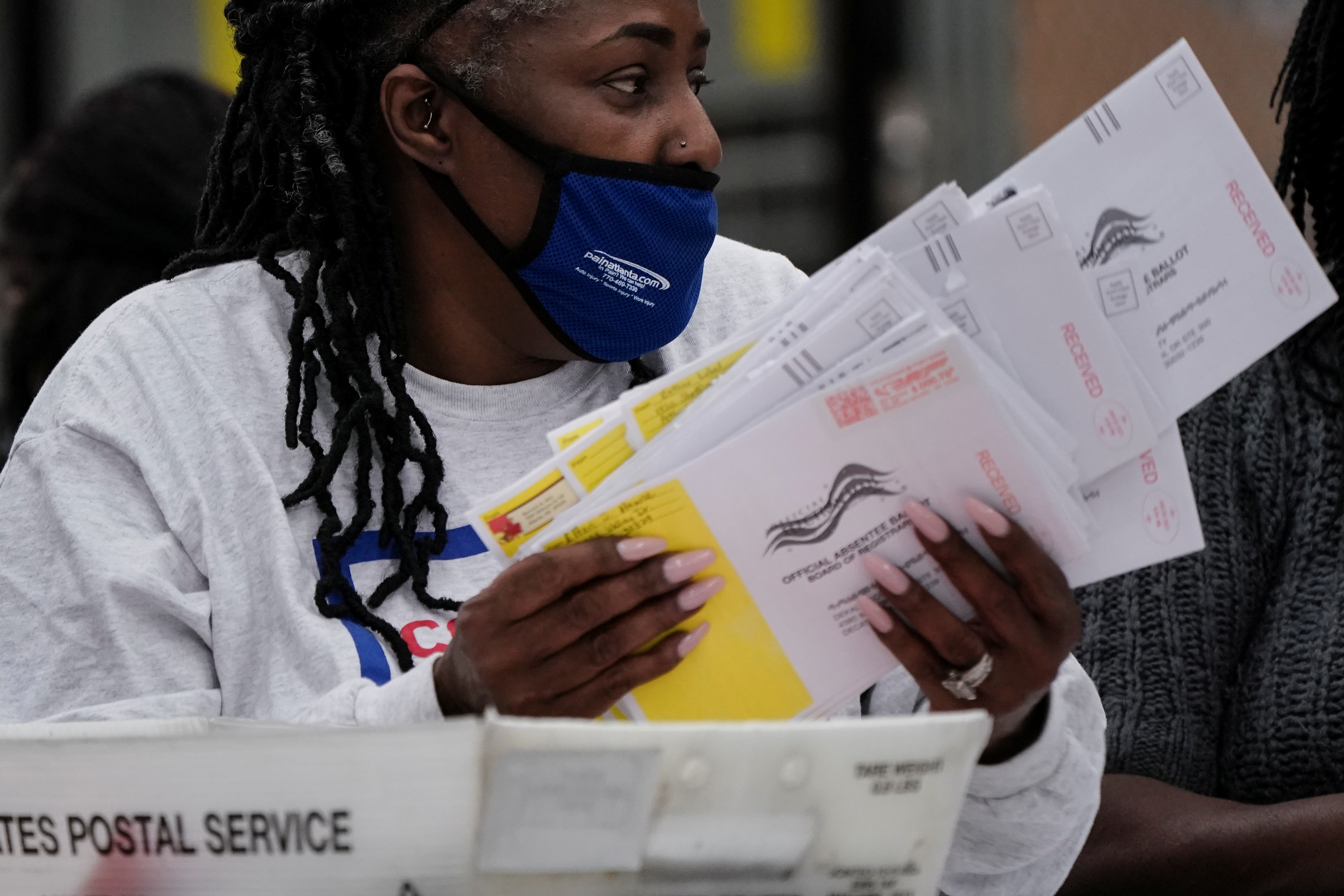 A DeKalb County election worker opens absentee ballot envelopes following the U.S. Senate runoff elections in Decatur, Georgia, U.S., January 6, 2021.  REUTERS/Elijah Nouvelage