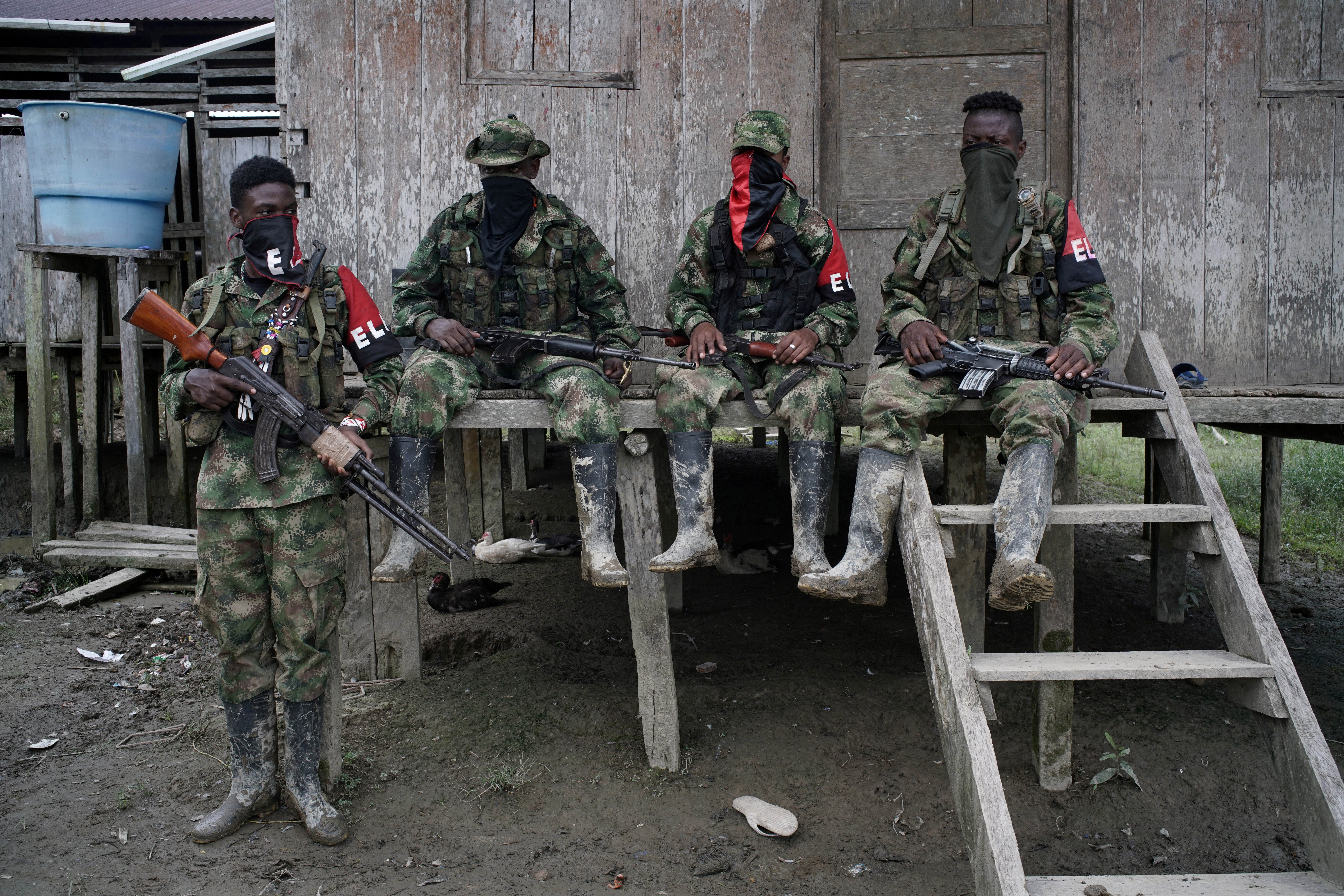 Rebels from Colombia's Marxist National Liberation Army (ELN) rest outside a house near the San Juan river