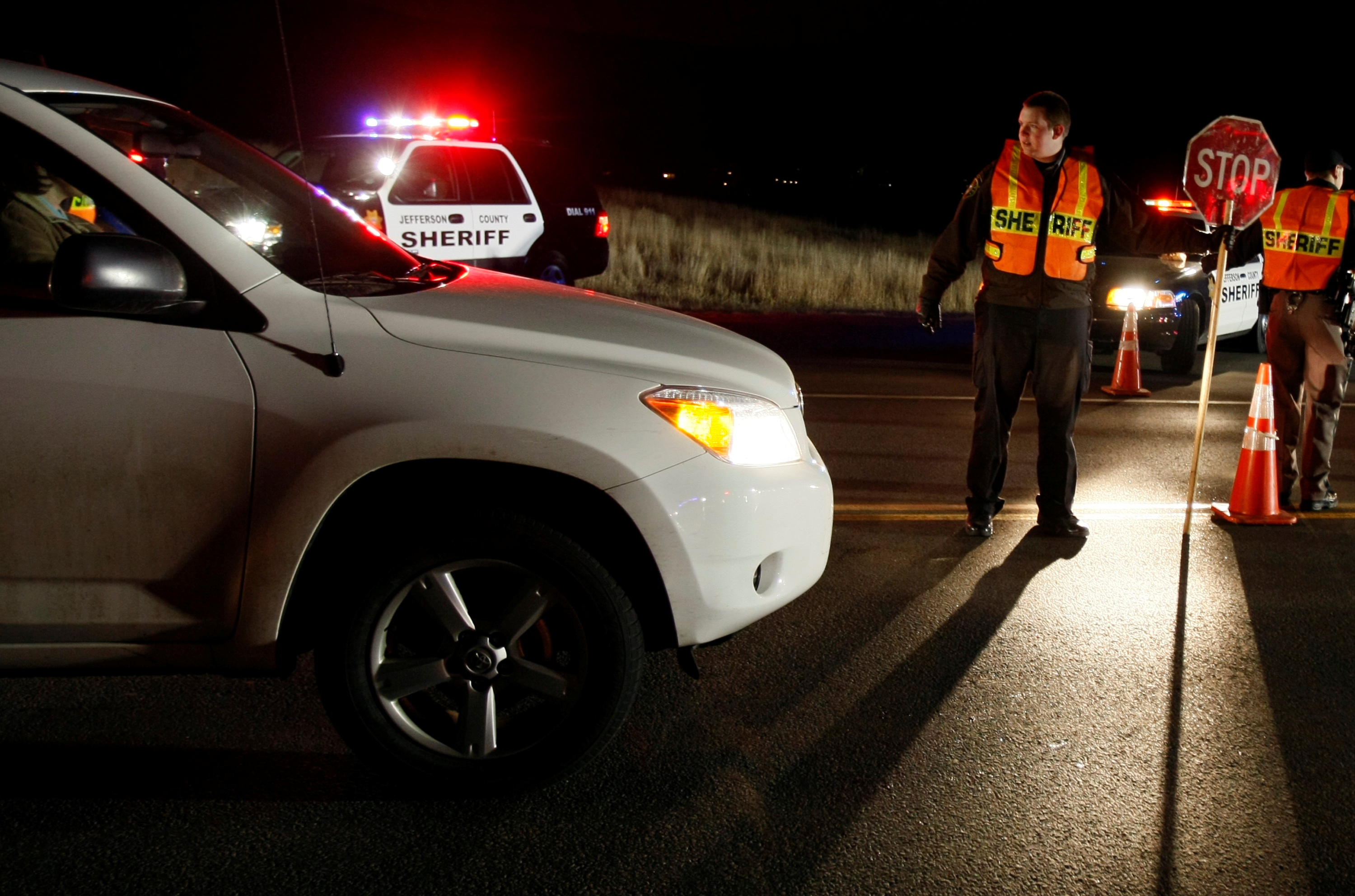 Jefferson County Sheriff Cadet Andrew Sevitts directs traffic as police stop drivers at a DUI checkpoint in Golden