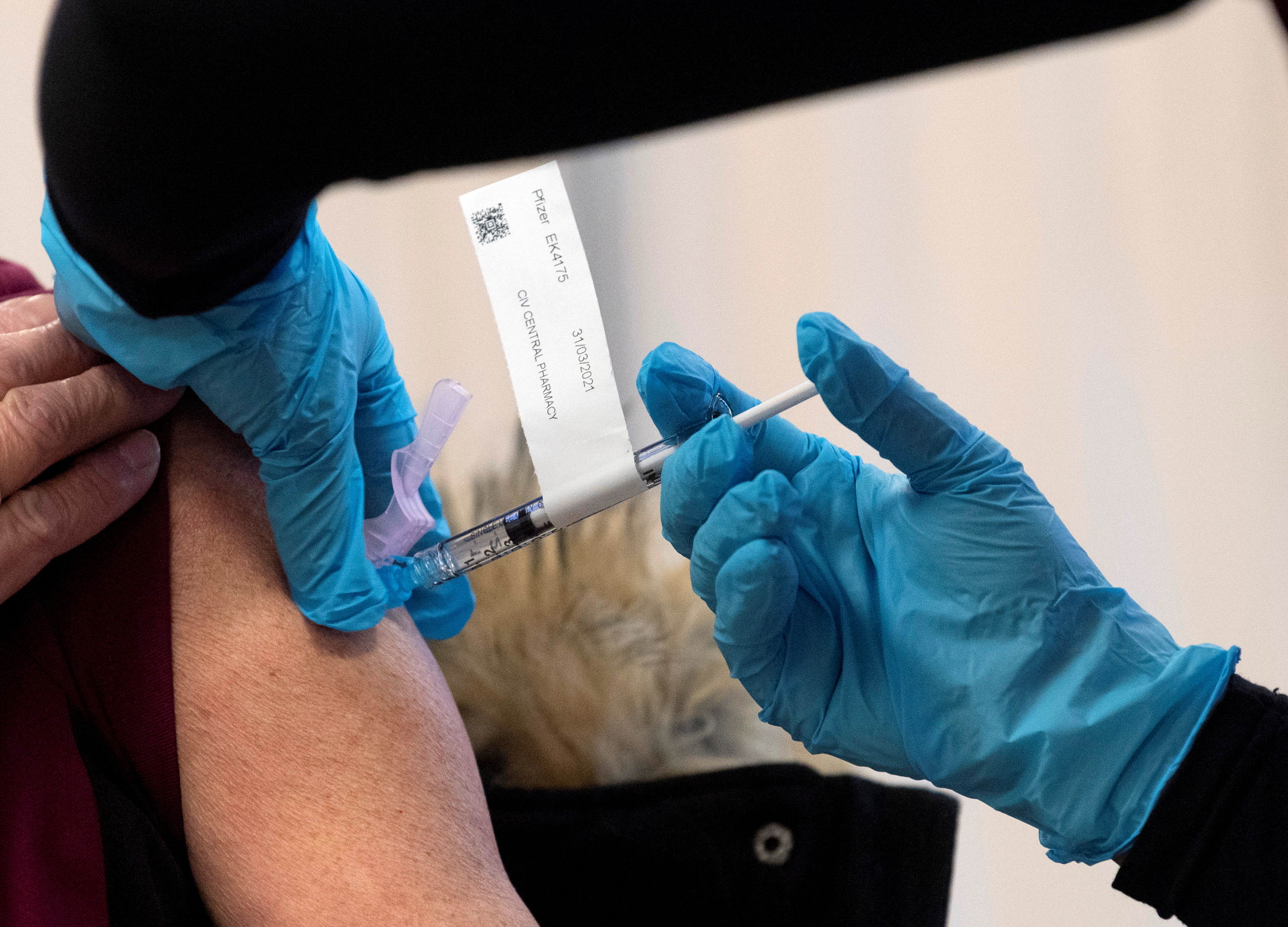 The Pfizer-BioNTech COVID-19 vaccine is administered to a personal support worker at the Civic Hospital in Ottawa, Ontario, Canada December 15, 2020. Adrian Wyld/Pool via REUTERS