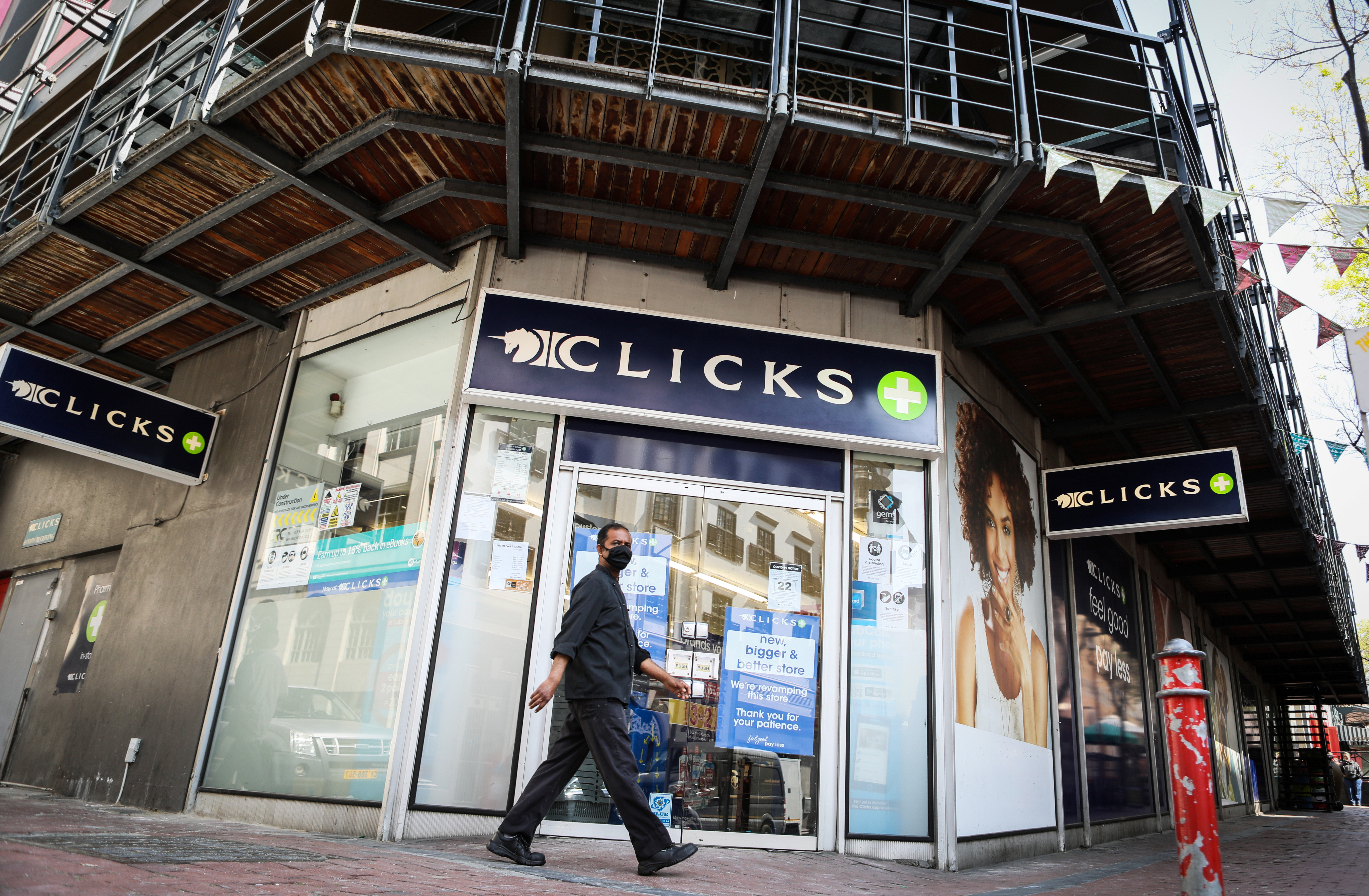 A man walks past a closed branch of  Clicks stores following protests in Cape Town