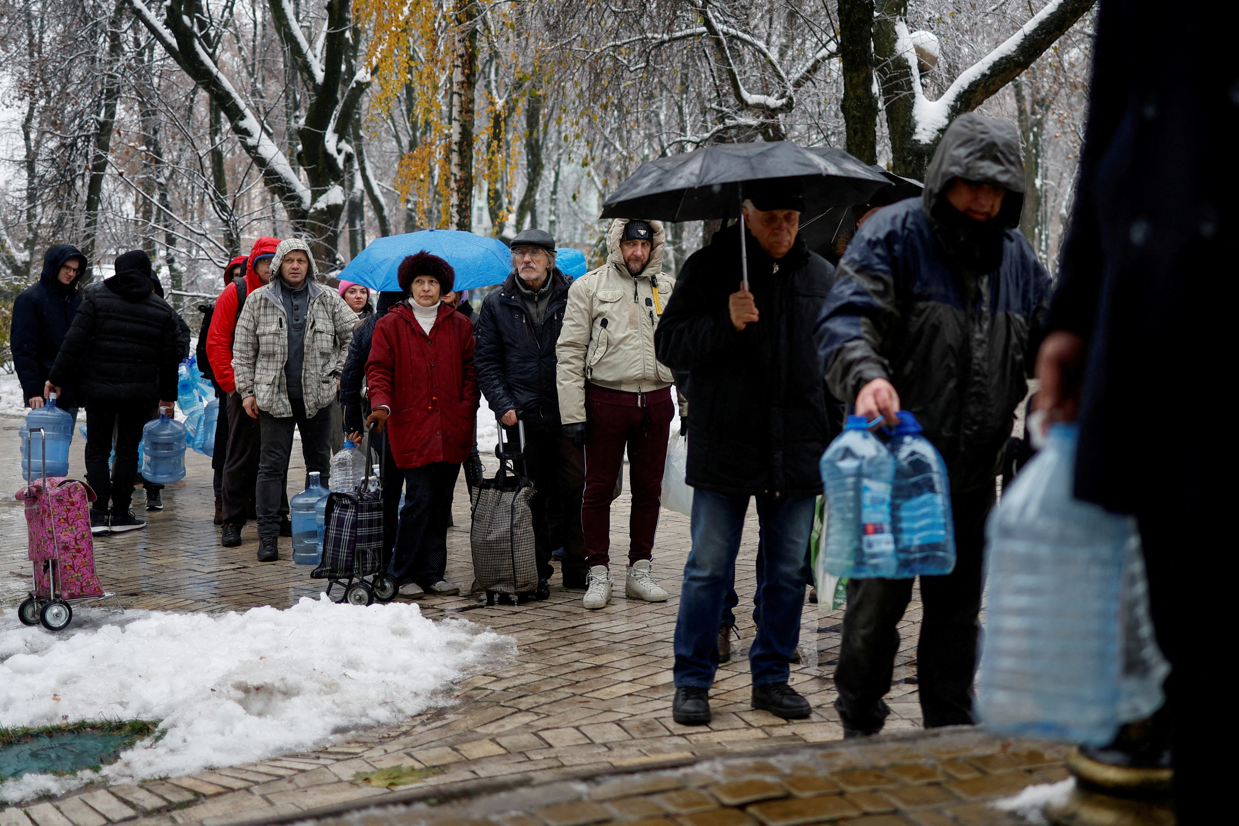 Local residents stand in line to fill up bottles with fresh drinking water in Kyiv