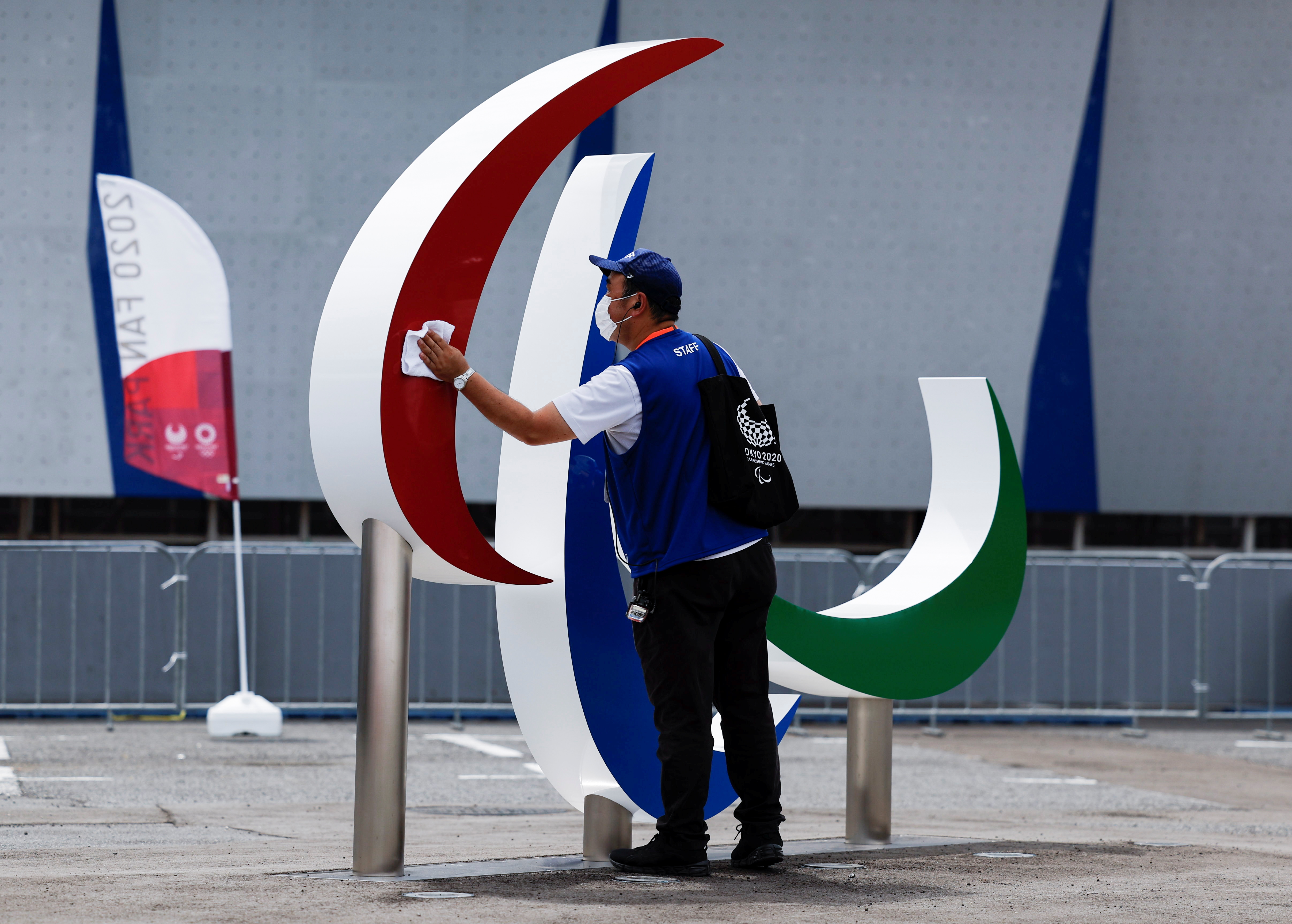 A staff member disinfects the monument of Paralympic symbol 'The three Agitos' in Tokyo