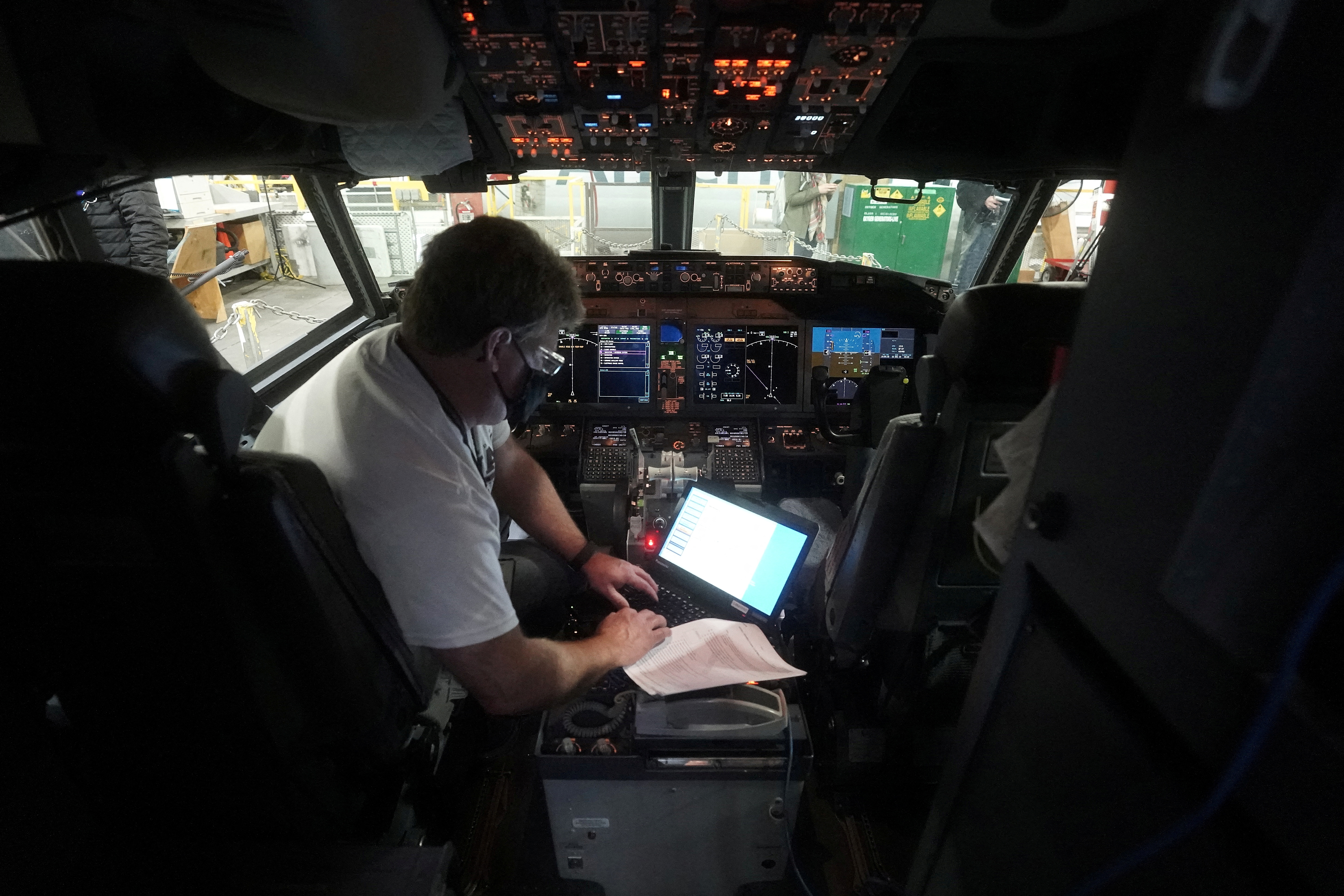 A worker loads new software into the Boeing 737 Max airplane in a maintenance hangar in Tulsa