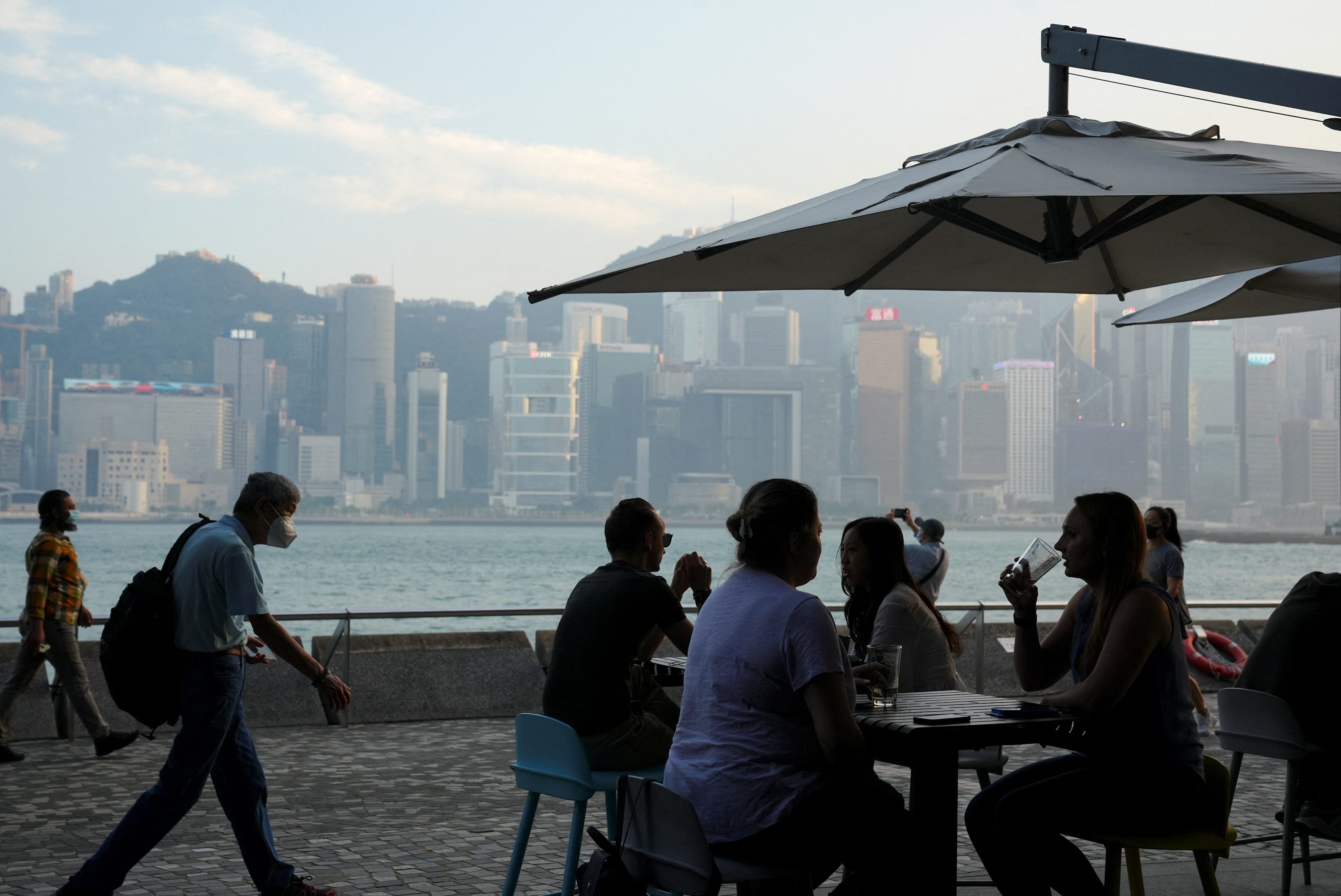People dine at a restaurant nearby Victoria Harbour after the government eased the coronavirus disease (COVID-19) restrictions on businesses, in Tsim Sha Tsui district in Hong Kong