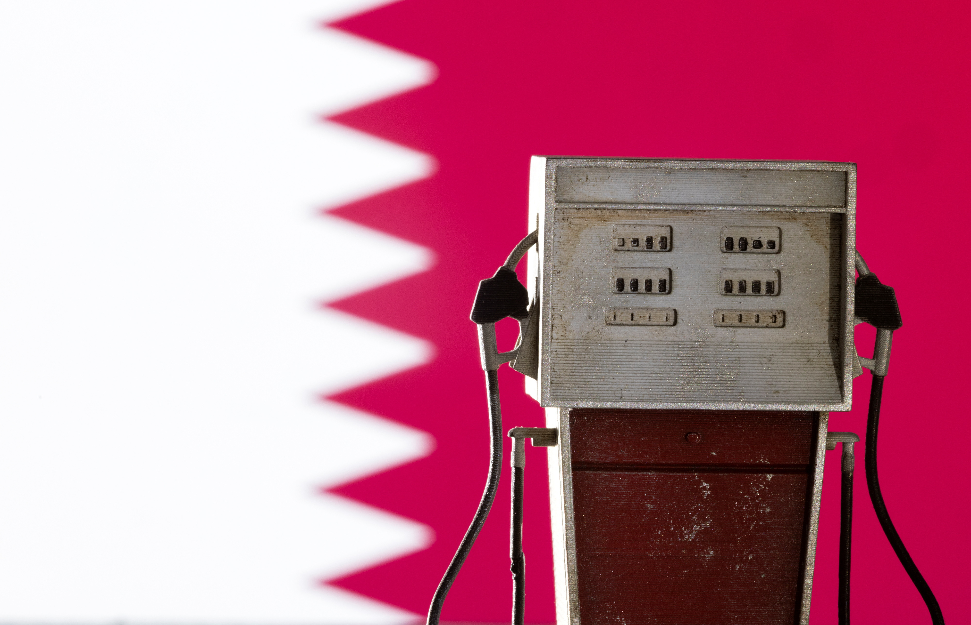 Illustration shows model of petrol pump and Qatar flag colors