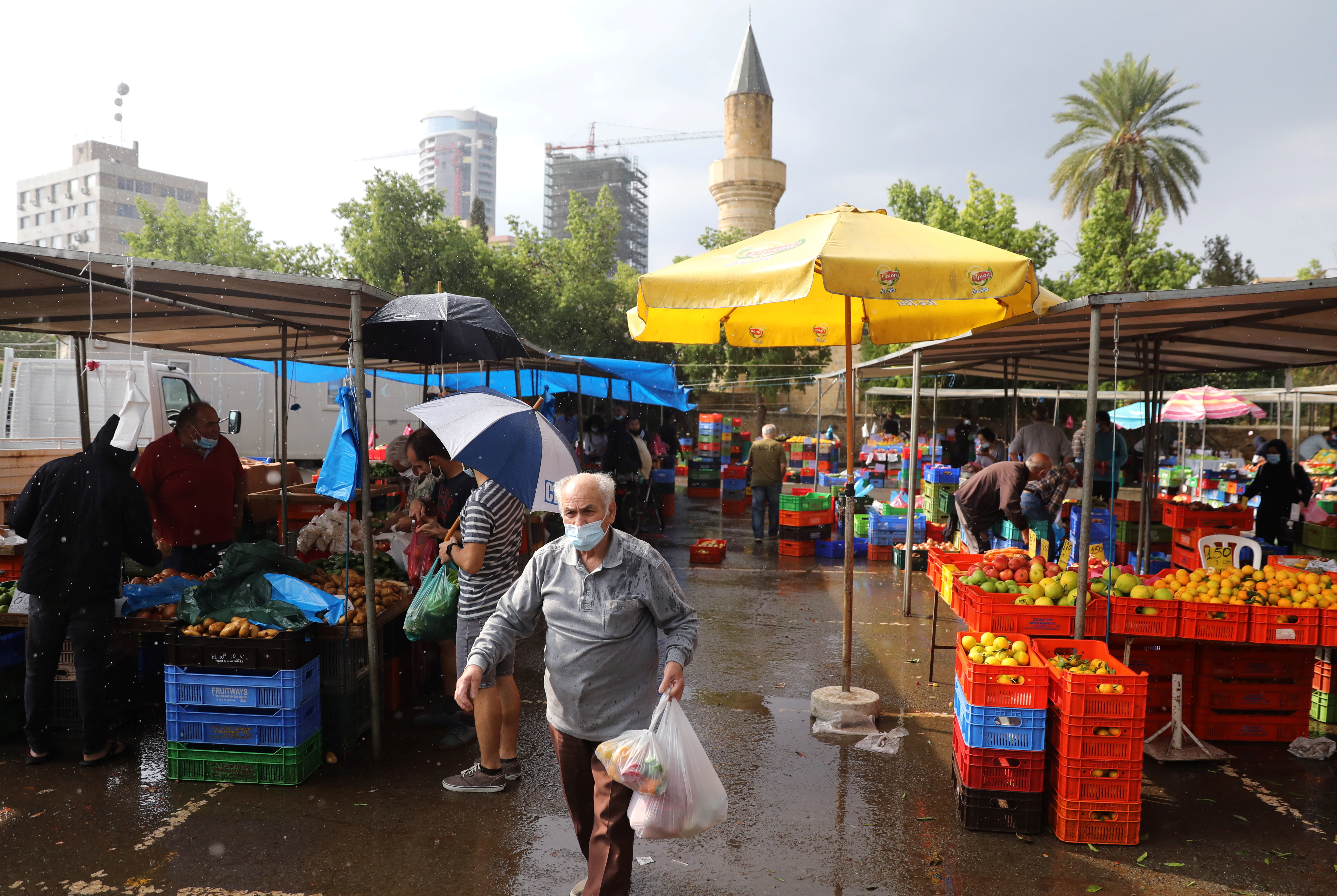 A man wearing a protective face mask walks in a local market amid the coronavirus disease (COVID-19) pandemic, in Nicosia