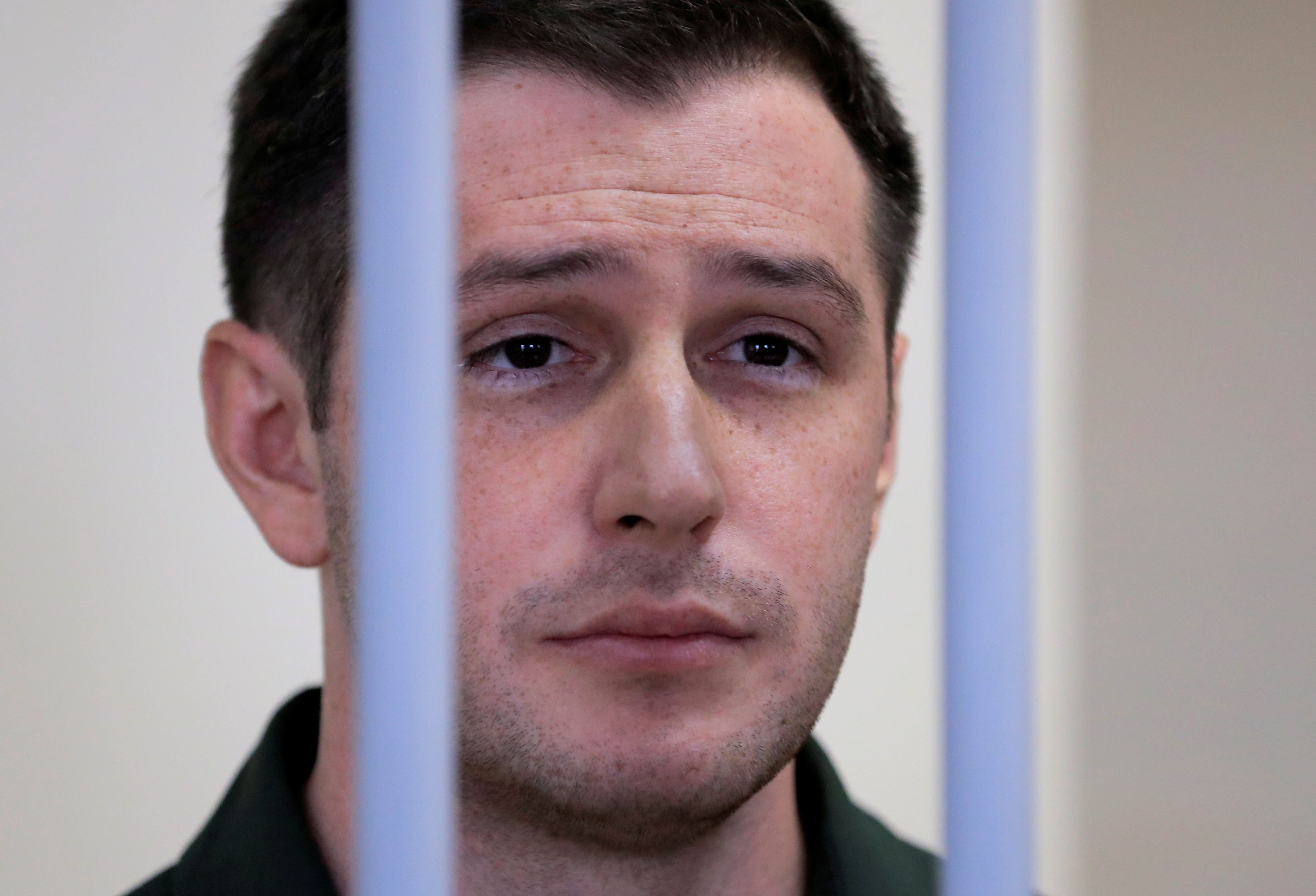 U.S. ex-Marine Trevor Reed, who was detained in 2019 and accused of assaulting police officers, stands inside a defendants' cage during a court hearing in Moscow, Russia March 11, 2020. REUTERS/Tatyana Makeyeva/File Photo