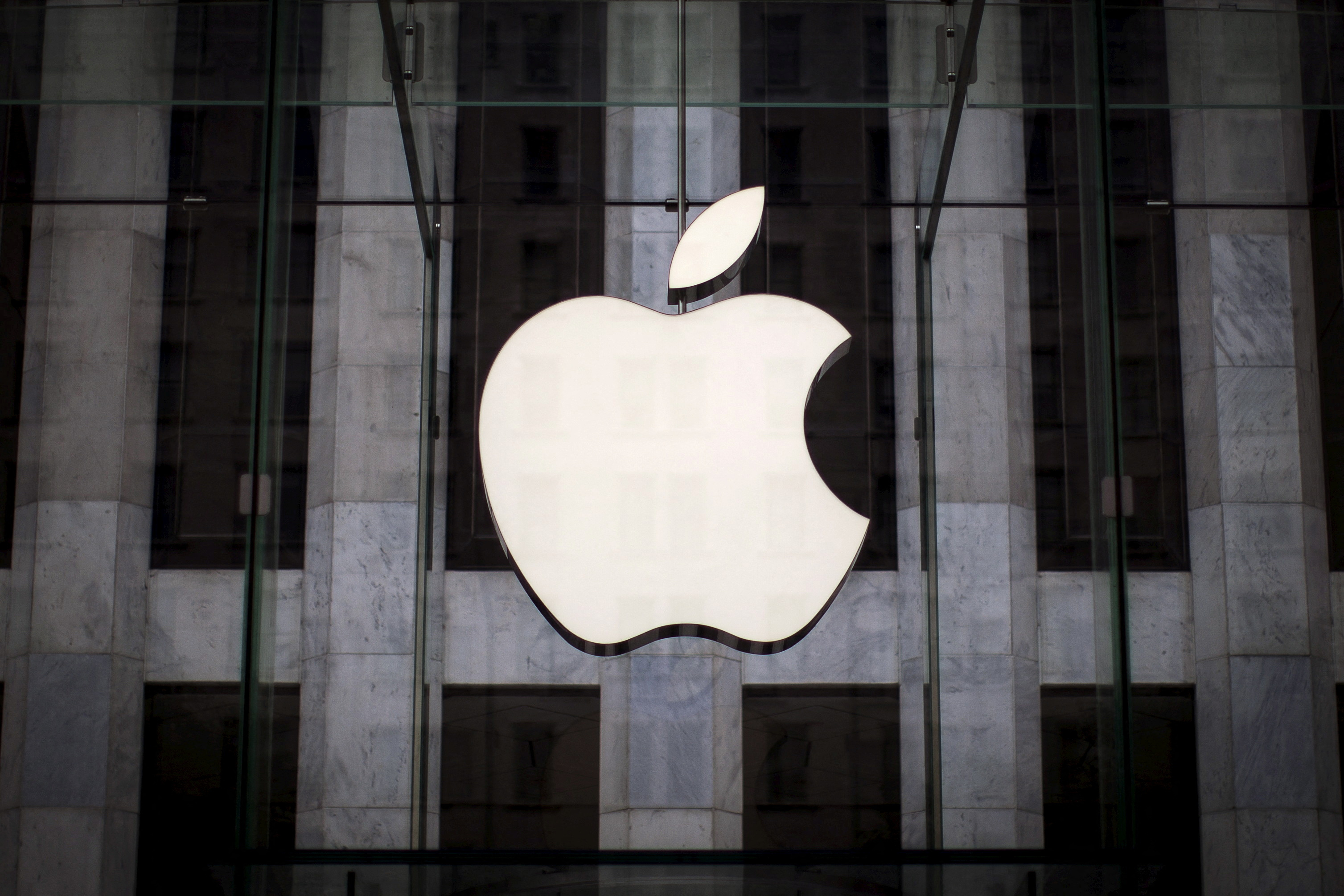 Un logotipo de Apple cuelga encima de la entrada de la Apple Store en la Quinta Avenida en el barrio de Manhattan en la ciudad de Nueva York