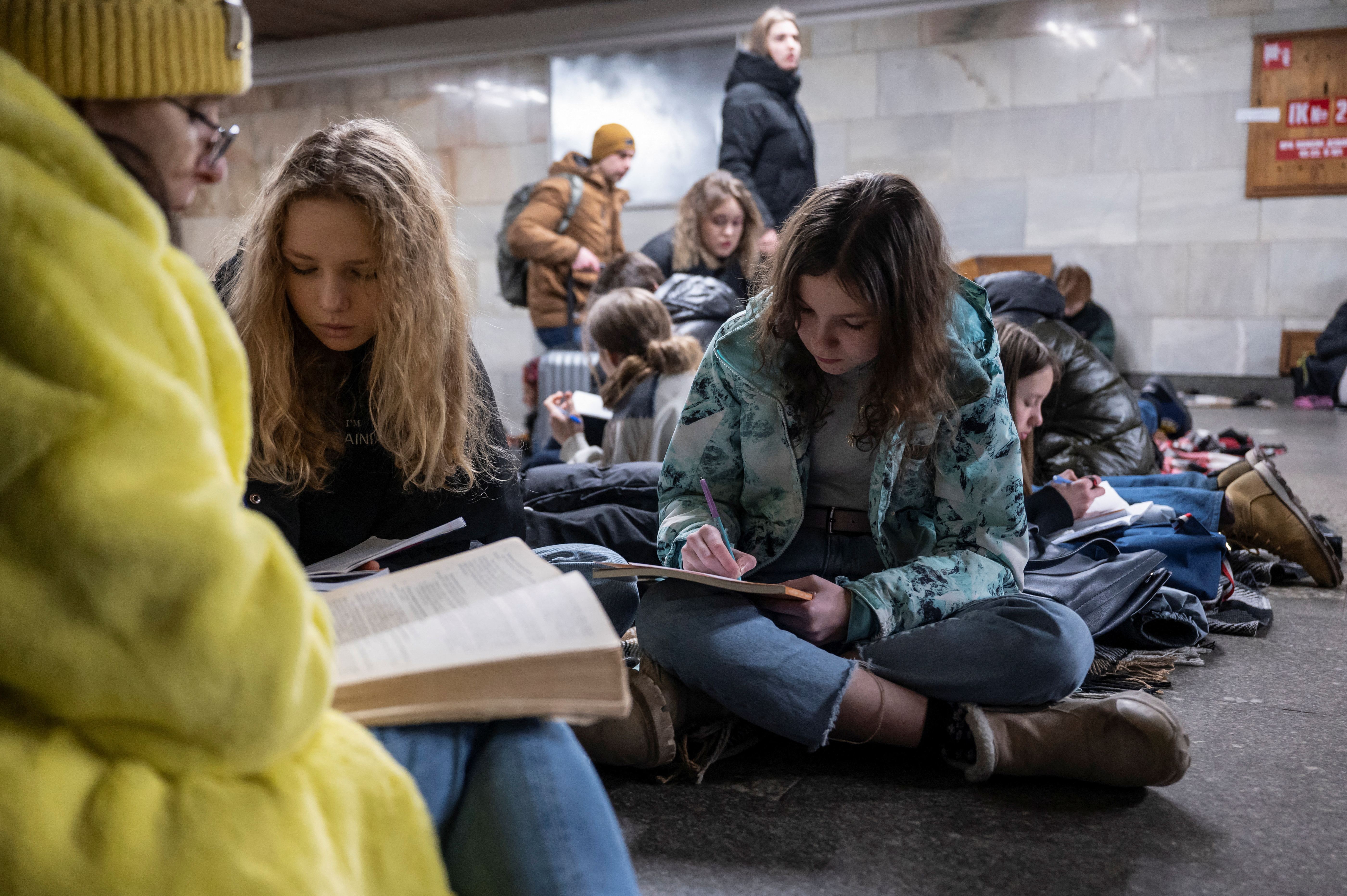 School students attend a lesson as they take shelter inside a metro station during massive Russian missile attacks in Kyiv