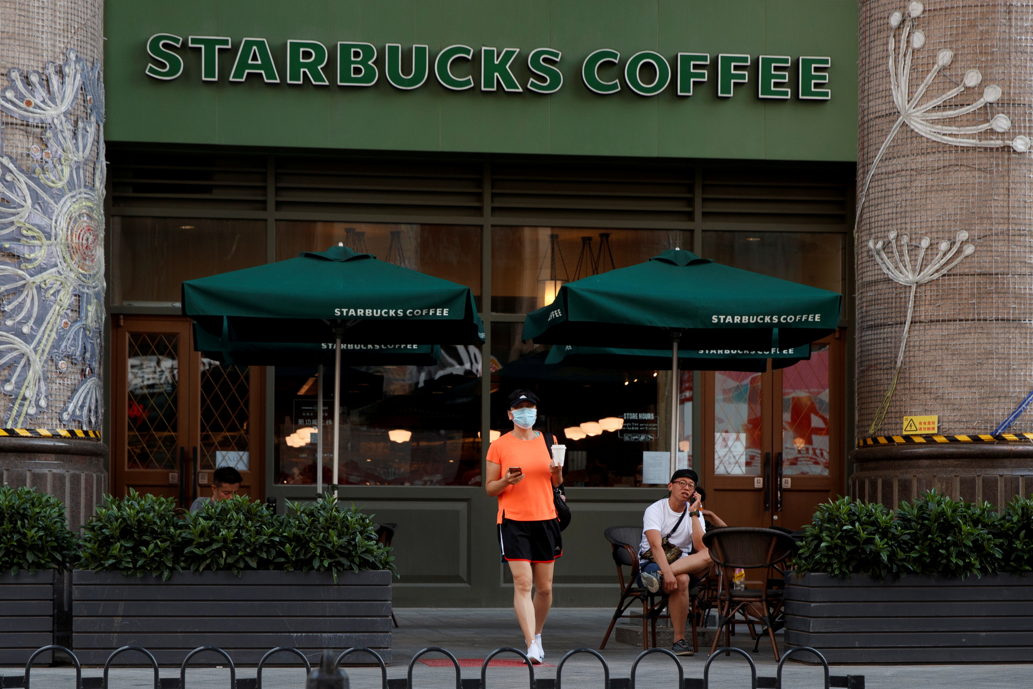 A woman leaves a cafe of Starbucks Coffee in Beijing
