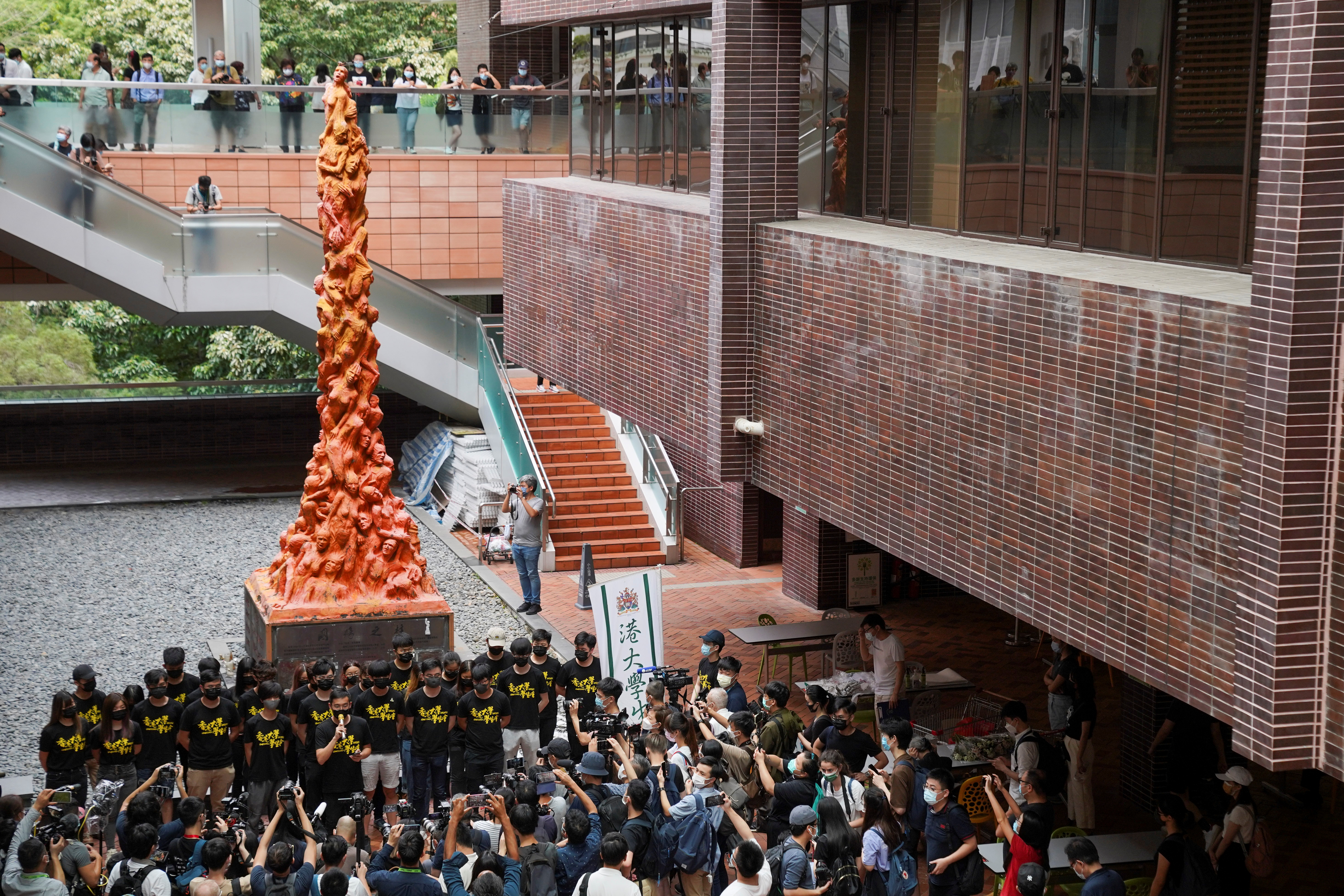 University students observe a minute of silence in front of the “Pillar of Shame” statue at the University of Hong Kong on the 32nd anniversary of the crackdown on pro-democracy demonstrators at Beijing's Tiananmen Square in 1989, in Hong Kong, China June 4, 2021. REUTERS/Lam Yik