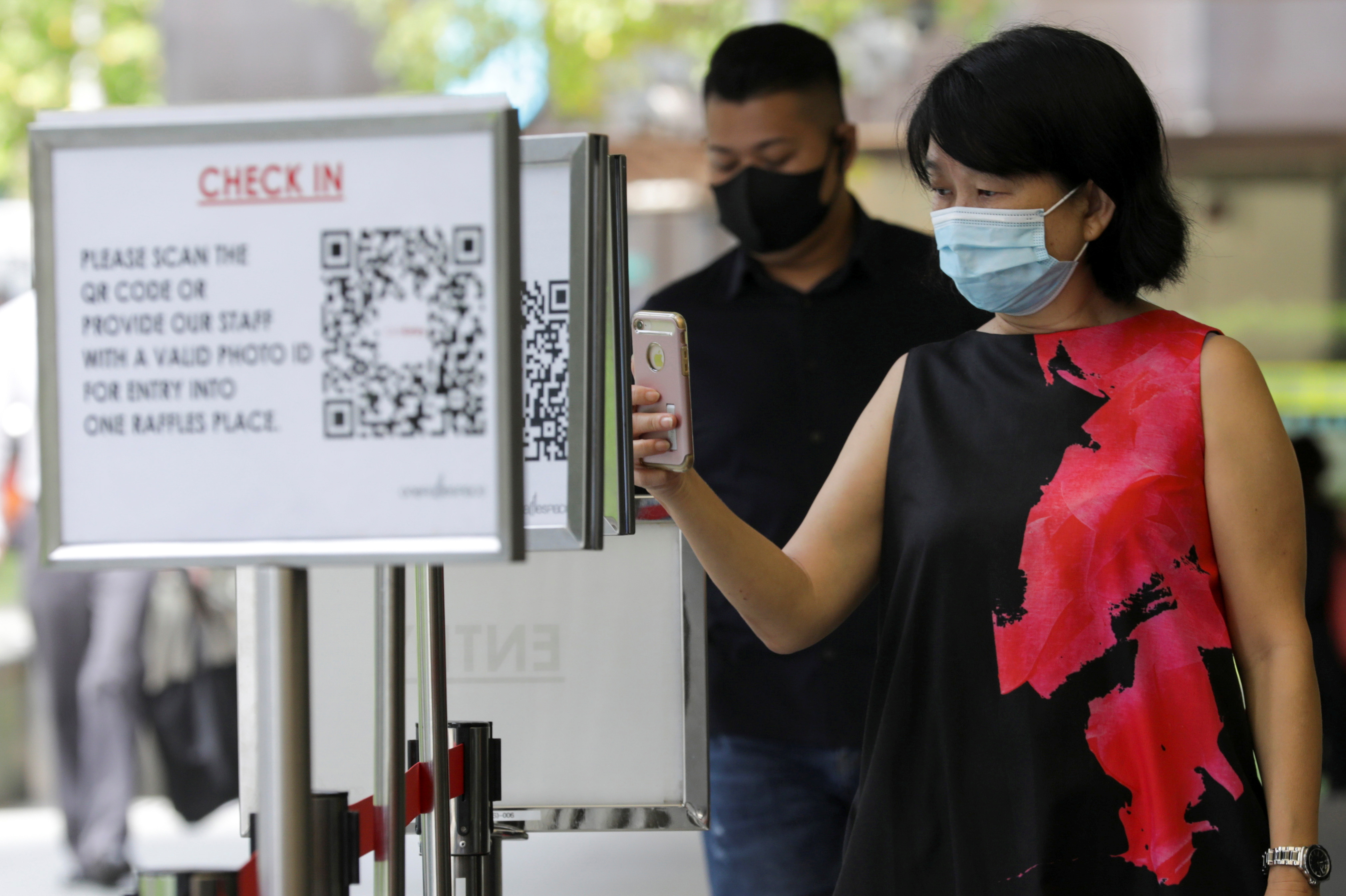 Office workers scan a Safe Entry QR code to enter a mall, amid the coronavirus disease (COVID-19) outbreak in Singapore