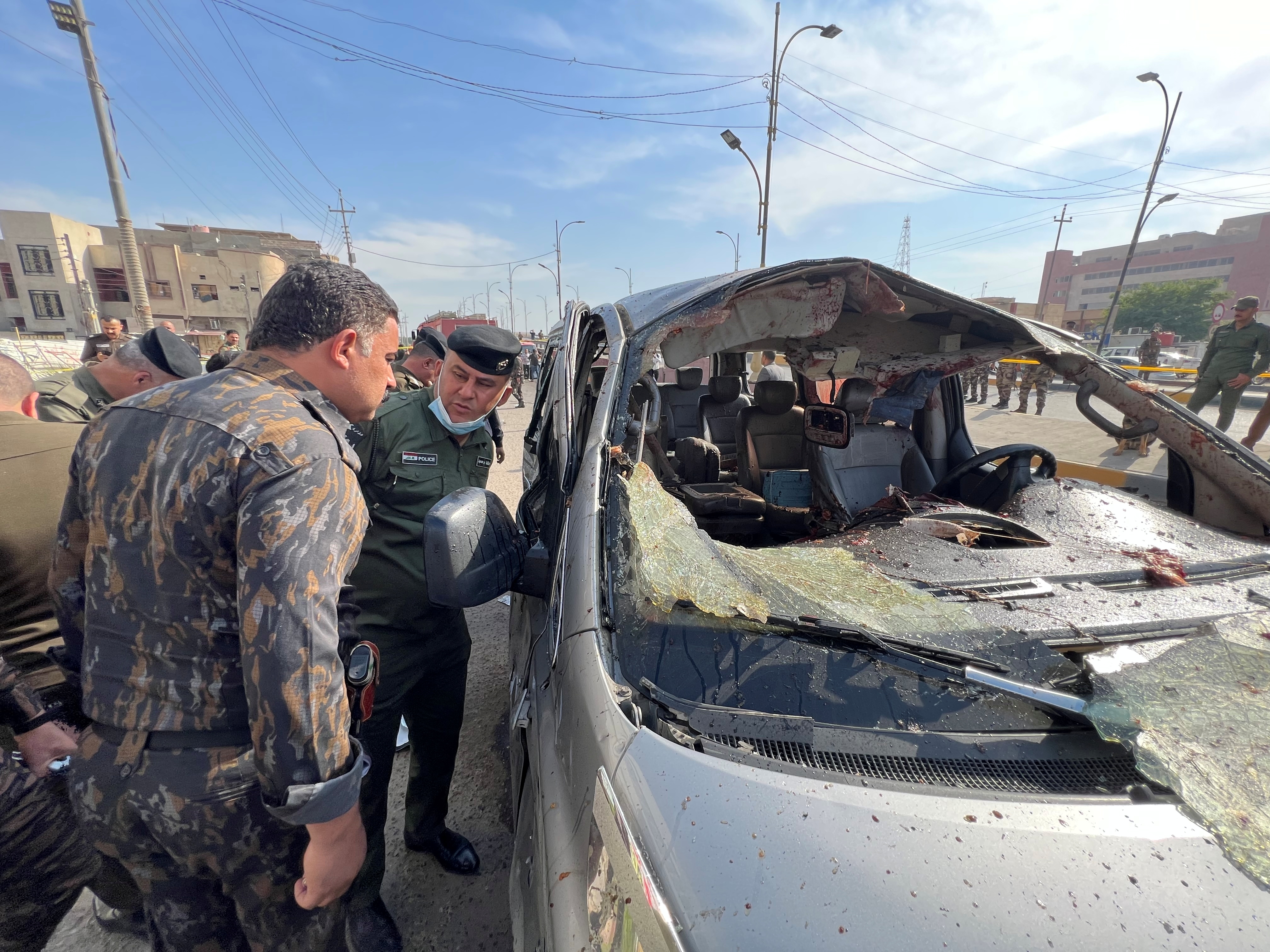 Iraqi security forces inspect the site of an explosion in Basra