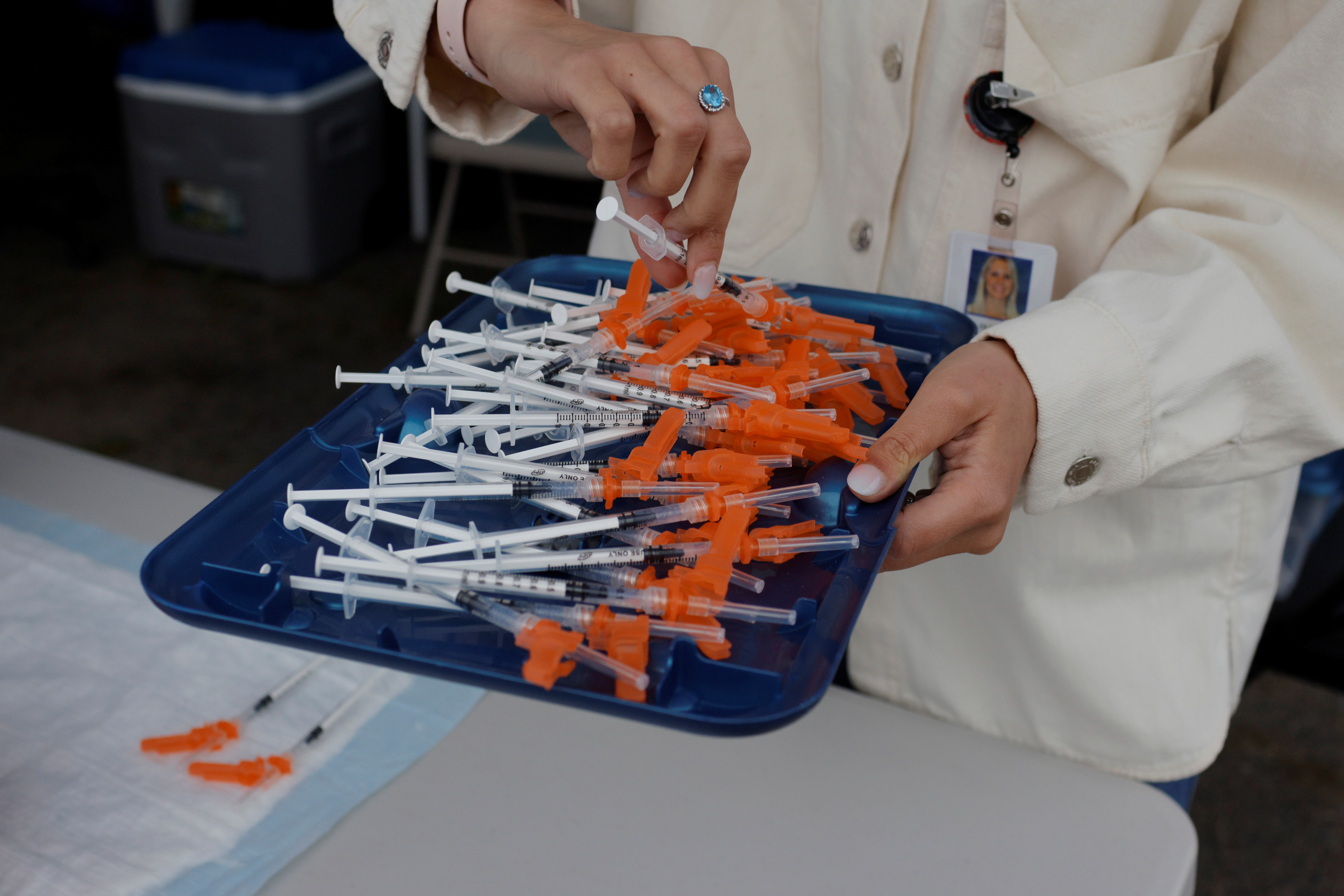 A doctor puts out syringes with the Pfizer vaccine at a coronavirus disease (COVID-19) vaccine clinic aimed at youths ages 12 or older at La Colaborativa in Chelsea, Massachusetts, U.S., June 11, 2021.   REUTERS/Brian Snyder/File Photo