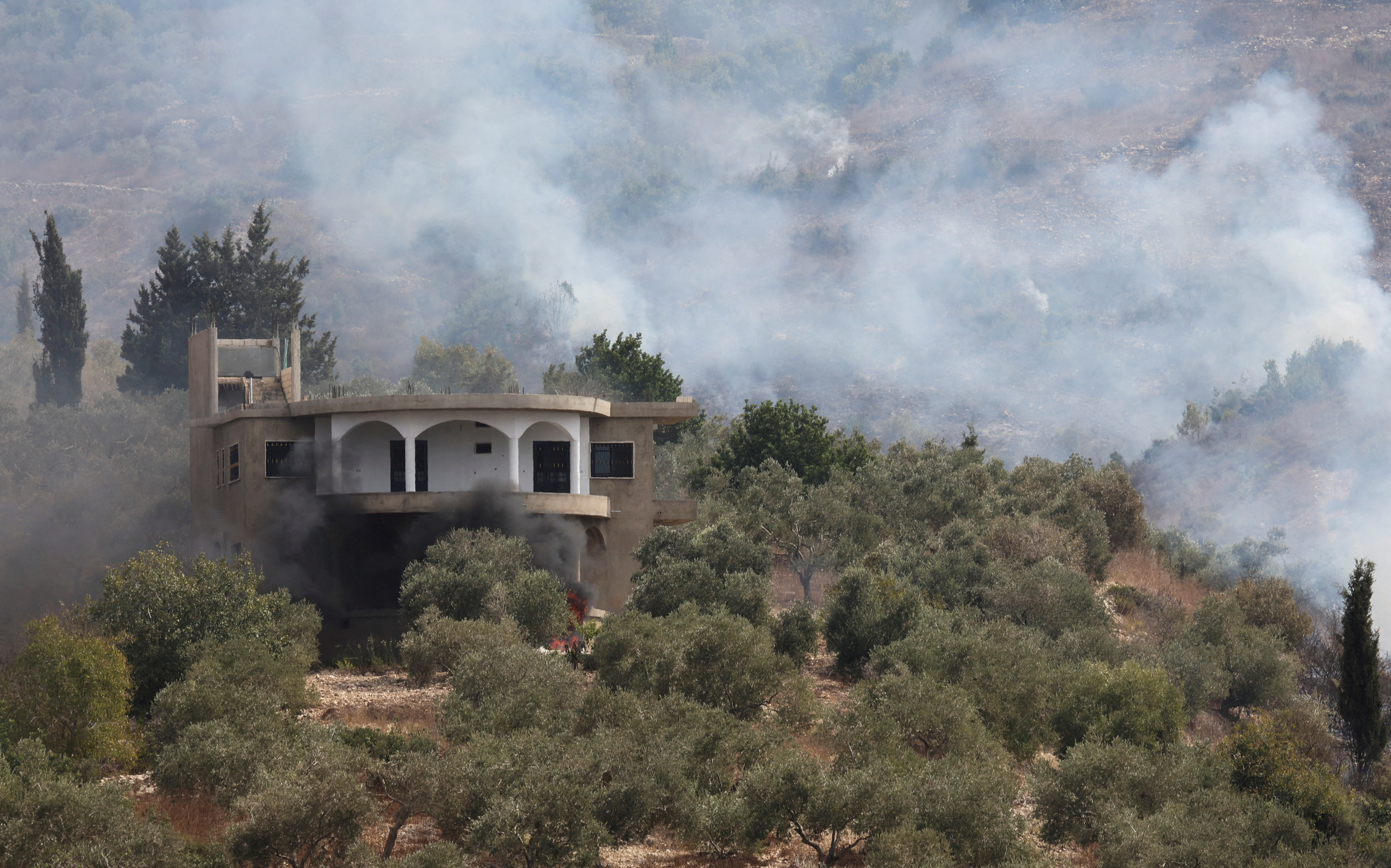Smoke rises after Israeli shelling in the village of Dhayra, near the border with Israel