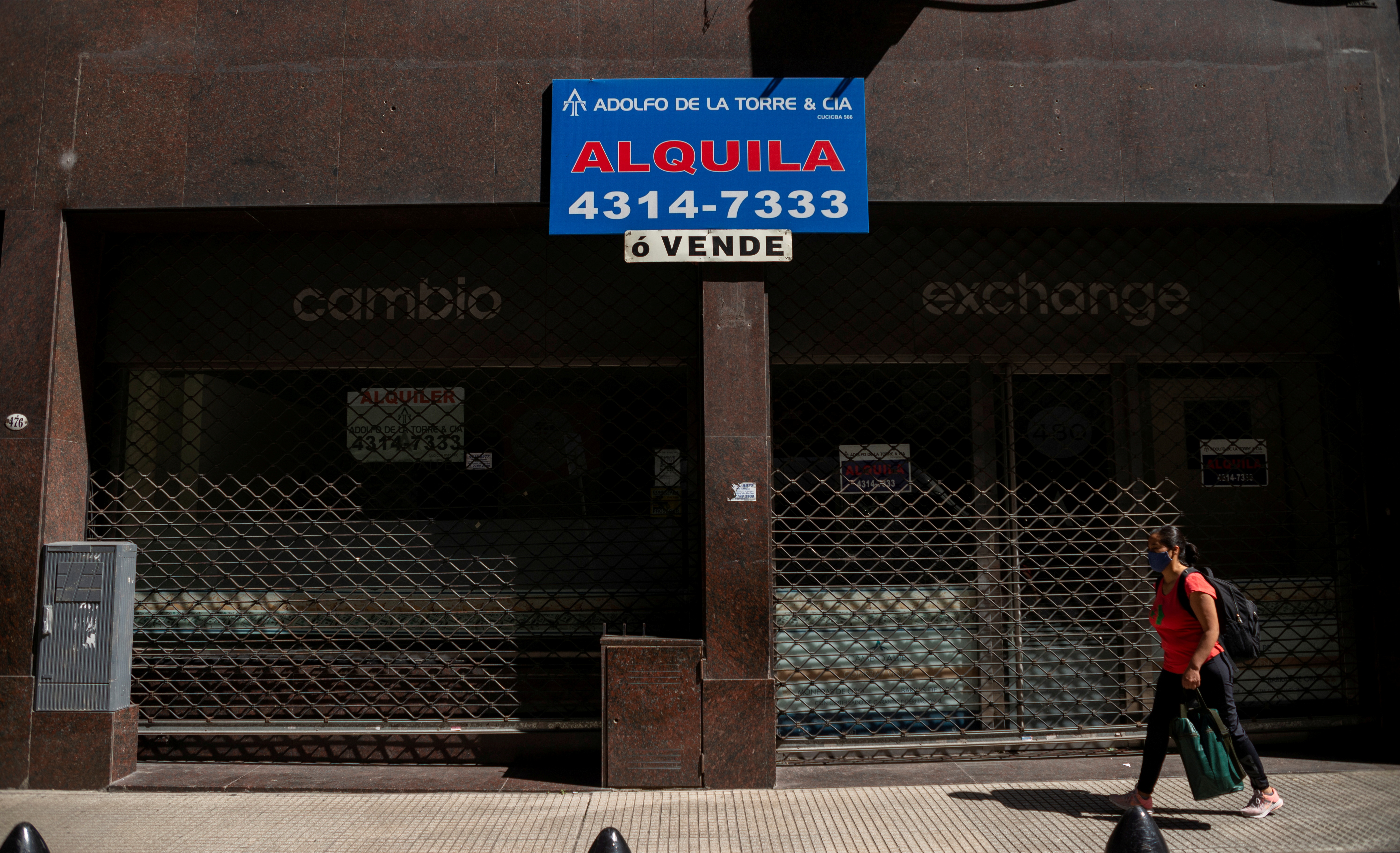 A pedestrian walks past an out-of-business currency exchange shop in downtown Buenos Aires, Argentina November 8, 2021. Picture taken November 8, 2021. REUTERS/Mariana Nedelcu/File Photo