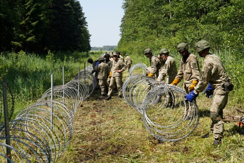 Lithuanian army soldiers install razor wire along the border with Belarus, in Druskininkai, Lithuania