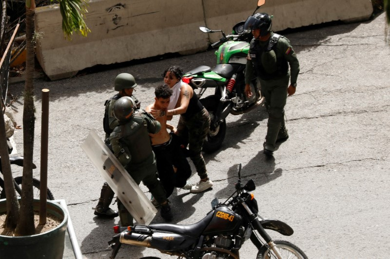 Bolivarian National Guard detain demonstrators, in Caracas