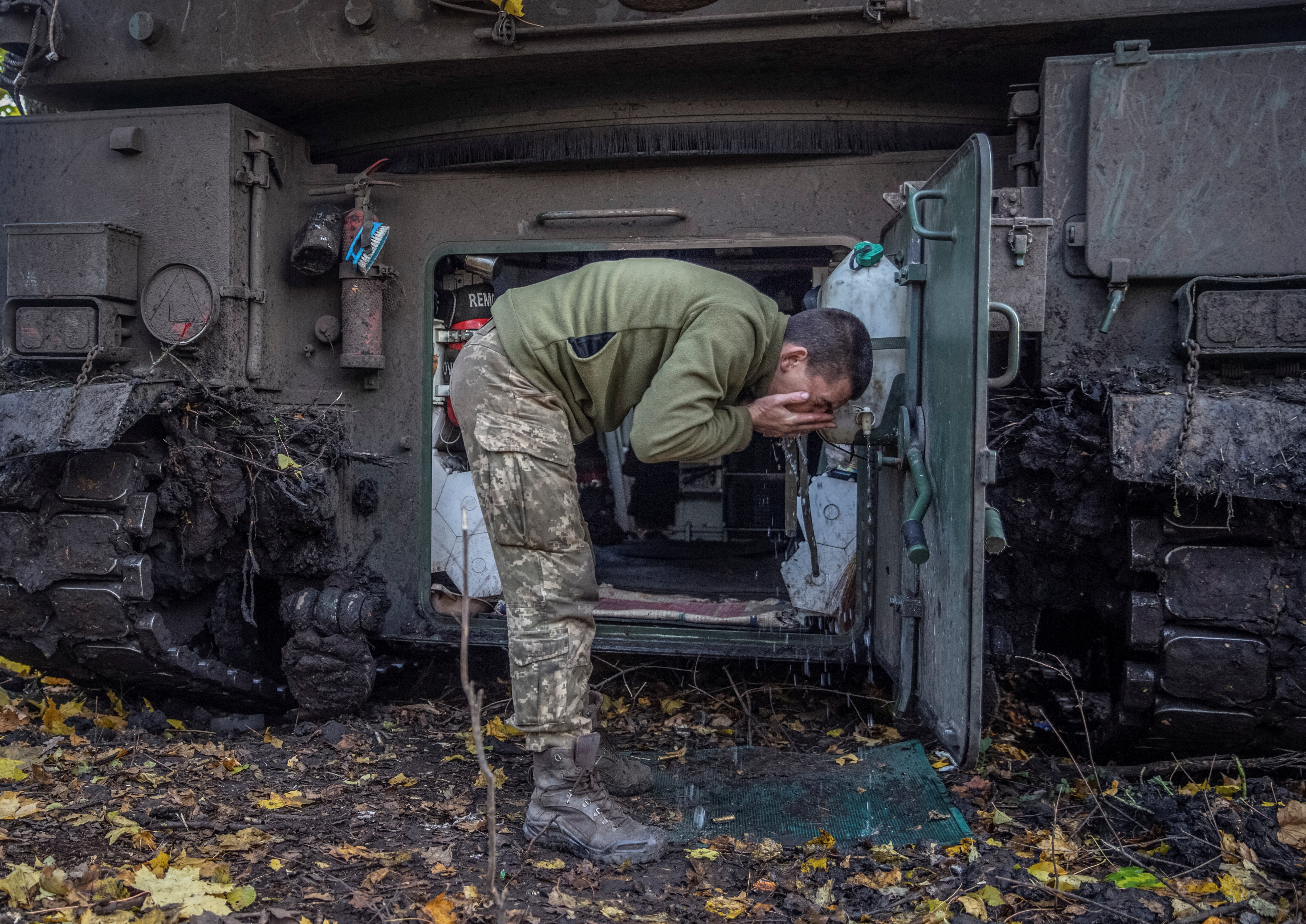 Ukrainian serviceman washes his face near a Polish self-propelled howitzer Krab after a fire toward Russian positions on a frontline in Donetsk region