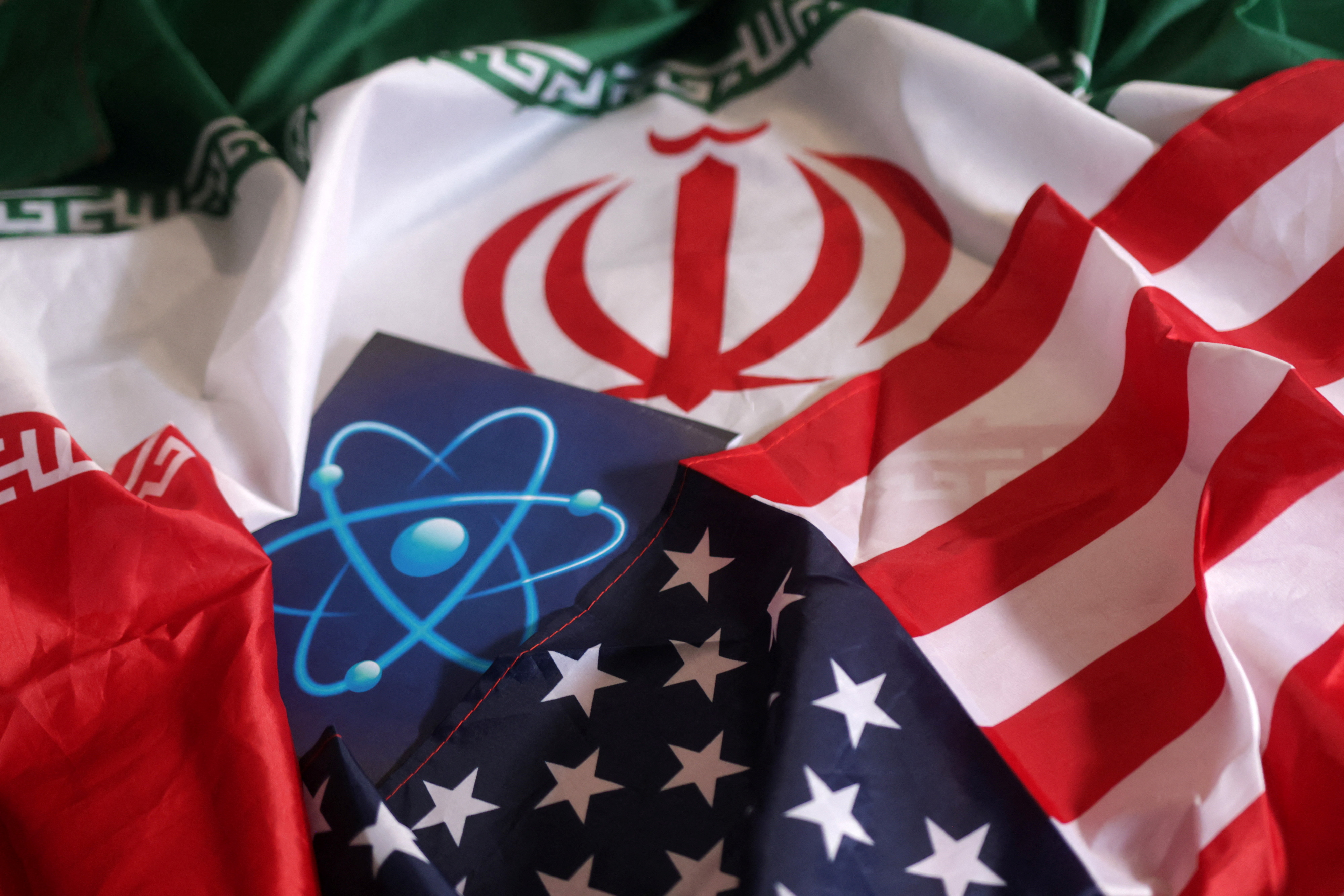 Illustration shows atomic symbol and USA and Iranian flags