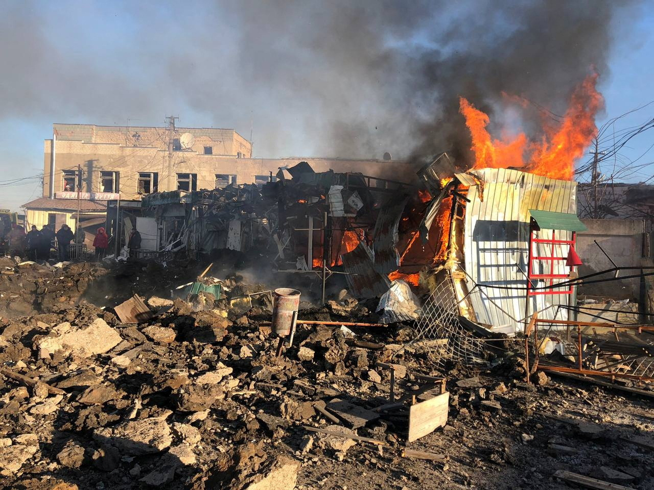 Building burns at a site of a market hit by Russian missiles in the town of Shevchenkove