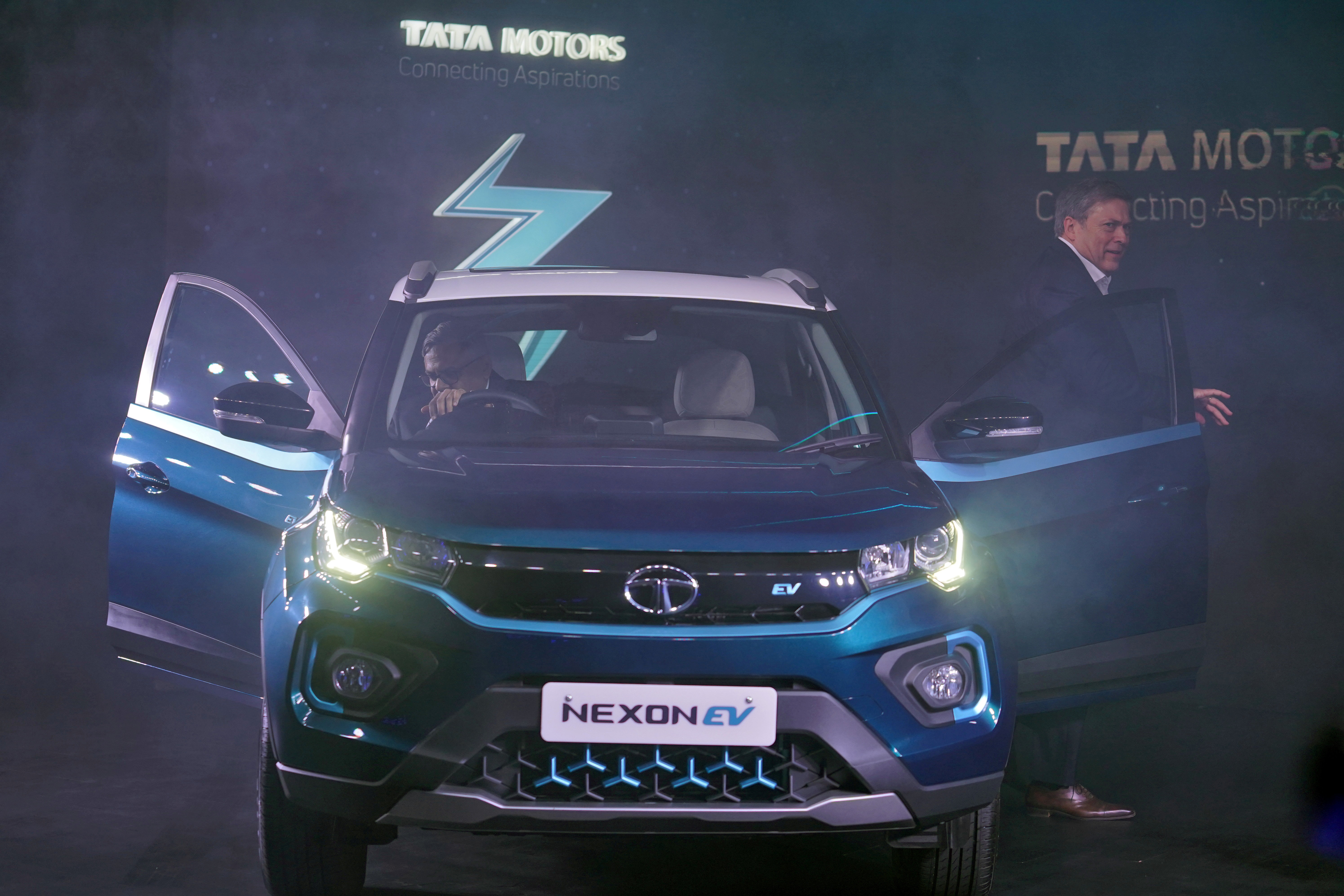 Natarajan Chandrasekaran, Chairman of Tata Sons, sits inside the company's electric sport-utility vehicle (SUV) Nexon EV next to Guenter Butschek, CEO and Managing Director at Tata Motors, during the launch of the vehicle in Mumbai