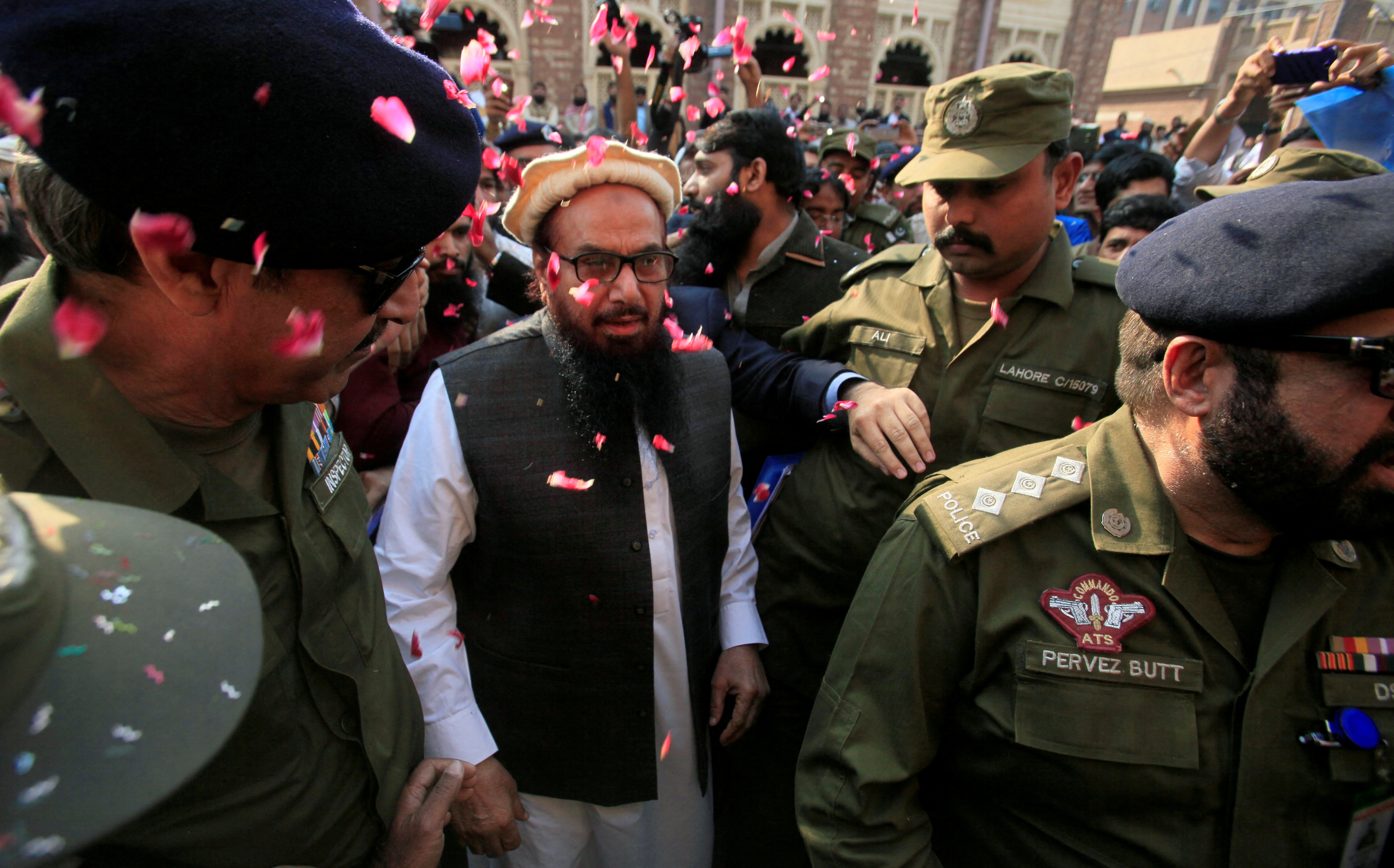 Hafiz Saeed is showered with flower petals as he walks to court before a Pakistani court ordered his release from house arrest in Lahore